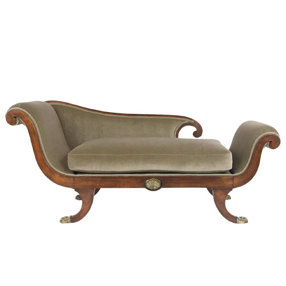 This 19th century Regency Style Chaise lounge is made out of mahogany wood and is in great condition. It has the original walnut color finish with a freshly waxed and polished finish. This chaise lounge has been newly reupholstered in an olive color