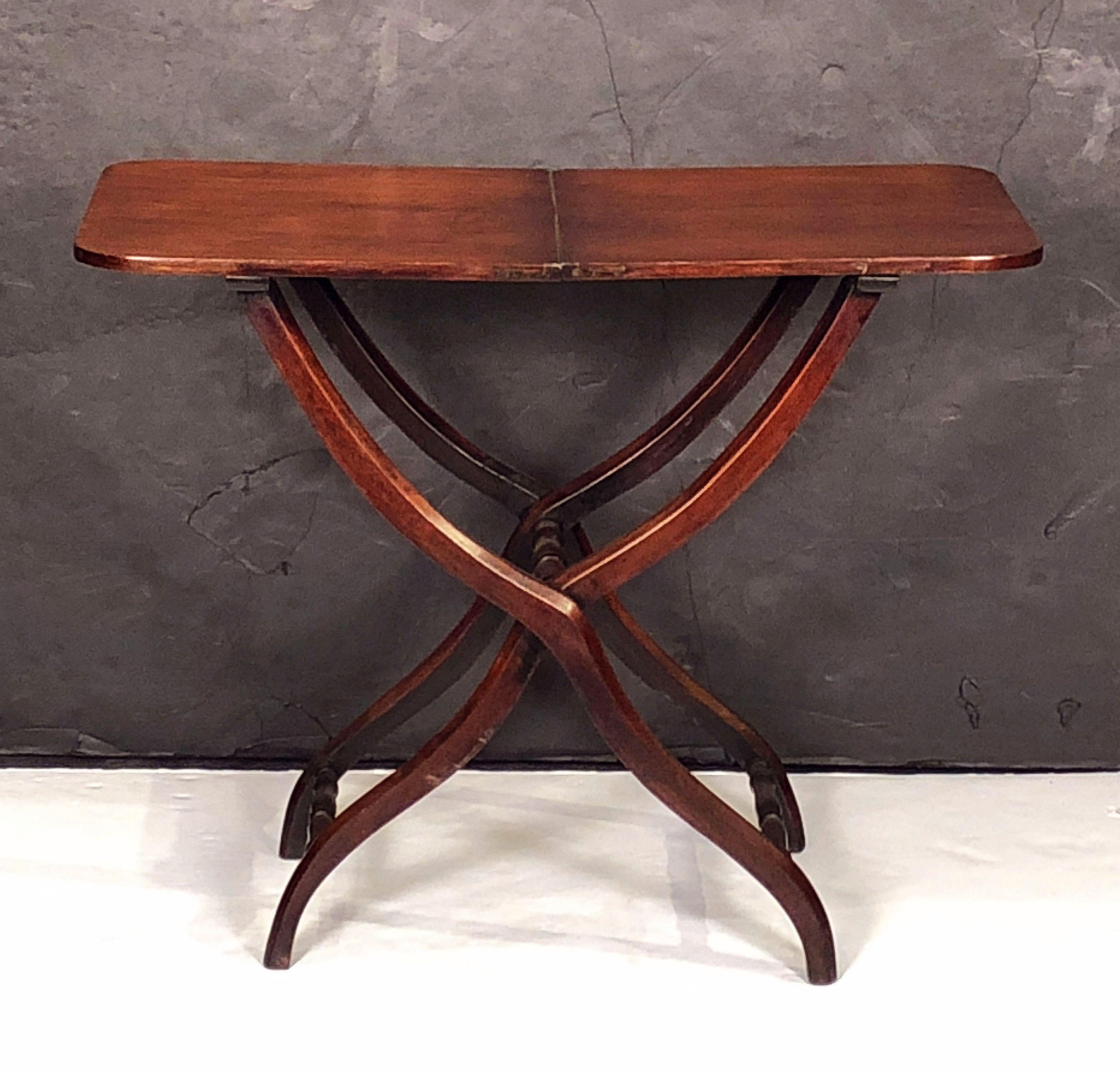 A fine 19th century English coaching or field table (folding) of mahogany featuring elegant serpentine-shaped turning for the supports, with brass hinges and a handsome patina to the wood.

Such tables were used in the age of carriages or coaches