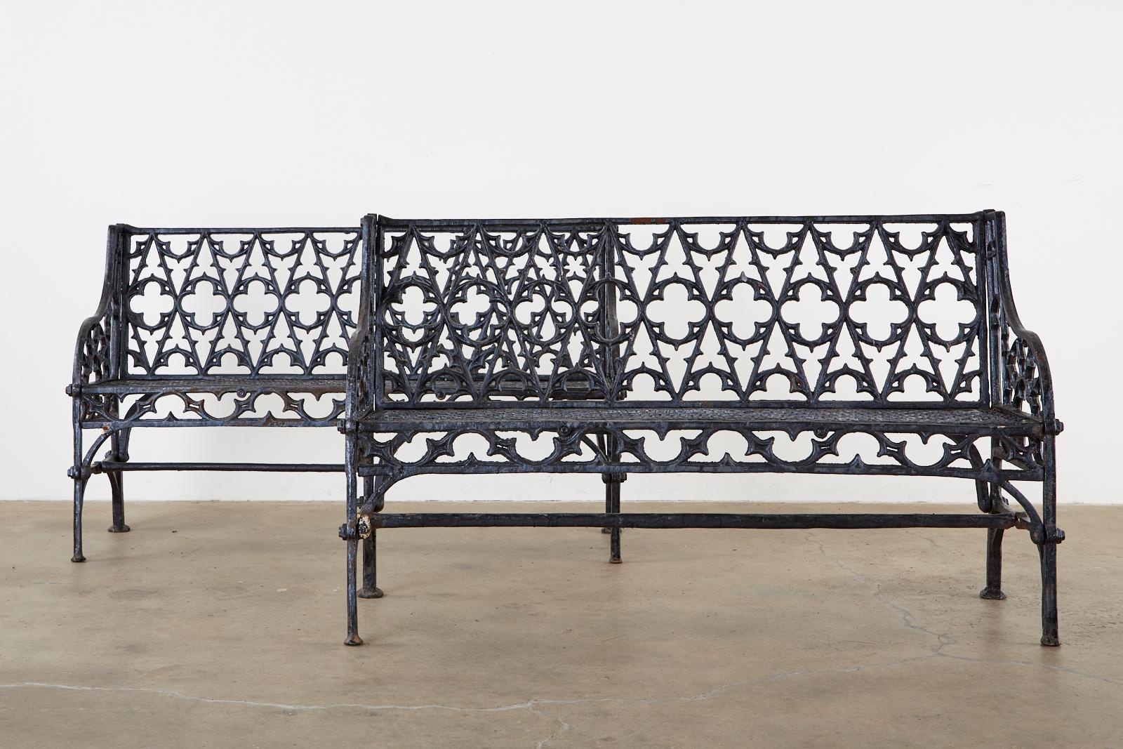 English Coalbrookdale foundry attributed cast iron garden benches. Made in the Gothic Revival English taste featuring Gothic tracery backrest centered by quatrefoil designs. The gracefully curved arms enclosing demilune motif patterns. The seat has