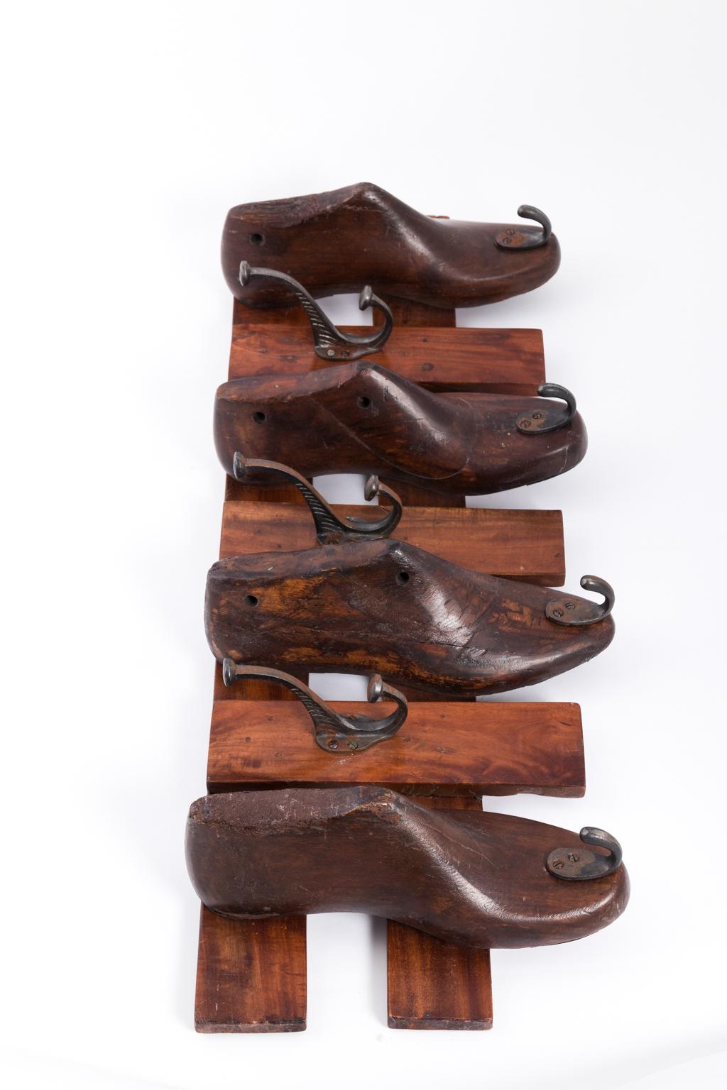 English coat track with hooks made of shoe inserts on two wooden boards, circa 1930s.
   