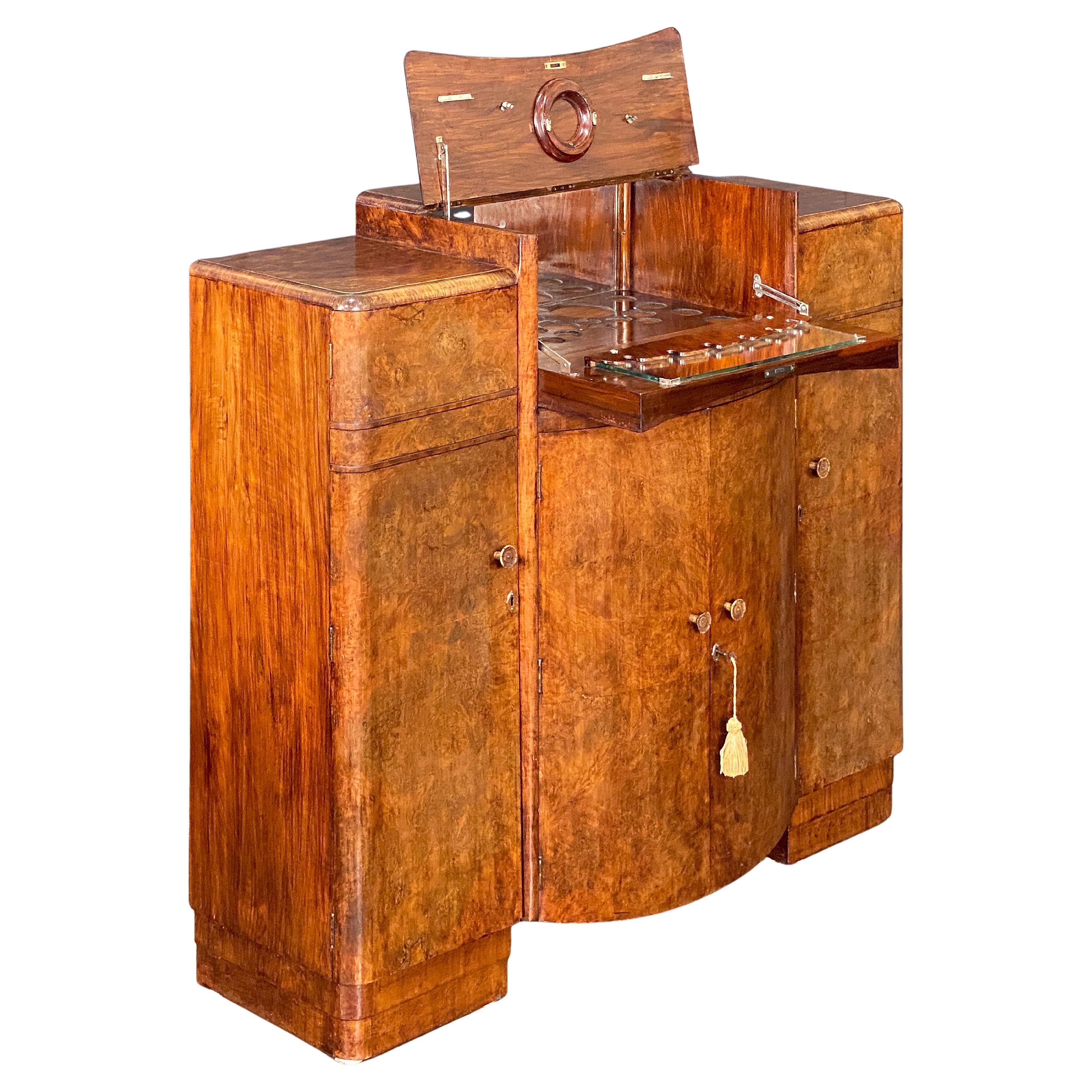 Un beau meuble de bar à cocktails ou armoire à boissons anglais - de la période Art Déco - avec un beau placage de ronce de noyer et une zone de service en miroir pour les spiritueux.

Cette pièce peut être entièrement fermée et verrouillée si