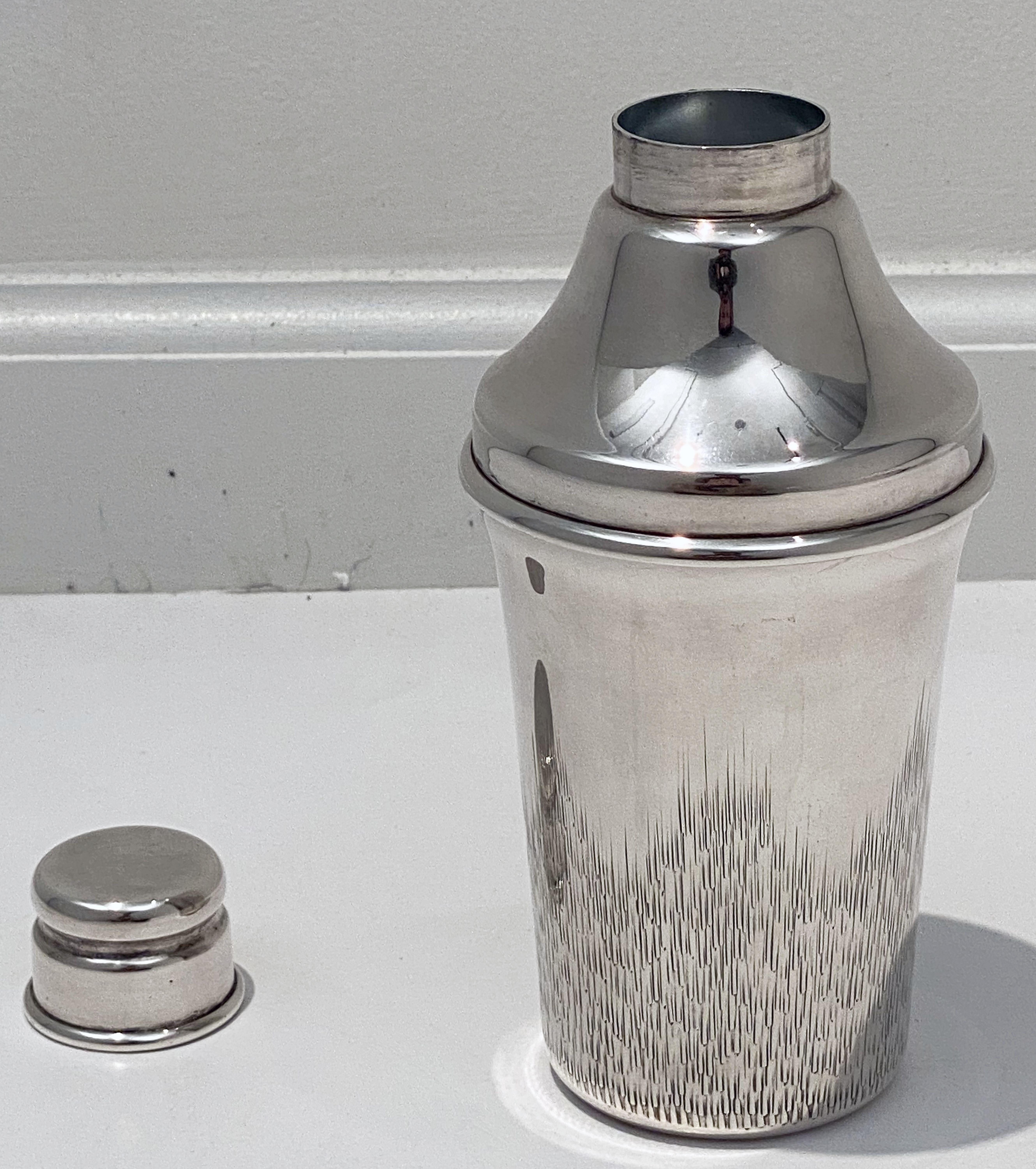 A vintage English cylindrical martini or cocktail shaker of fine plate silver, with engine-turned removable CAP and strainer.

Marked on base: PSL, Parkin Silversmiths, Sheffield, England (or E.H. Parkin & Co.)

Perfect for the bar. Even better