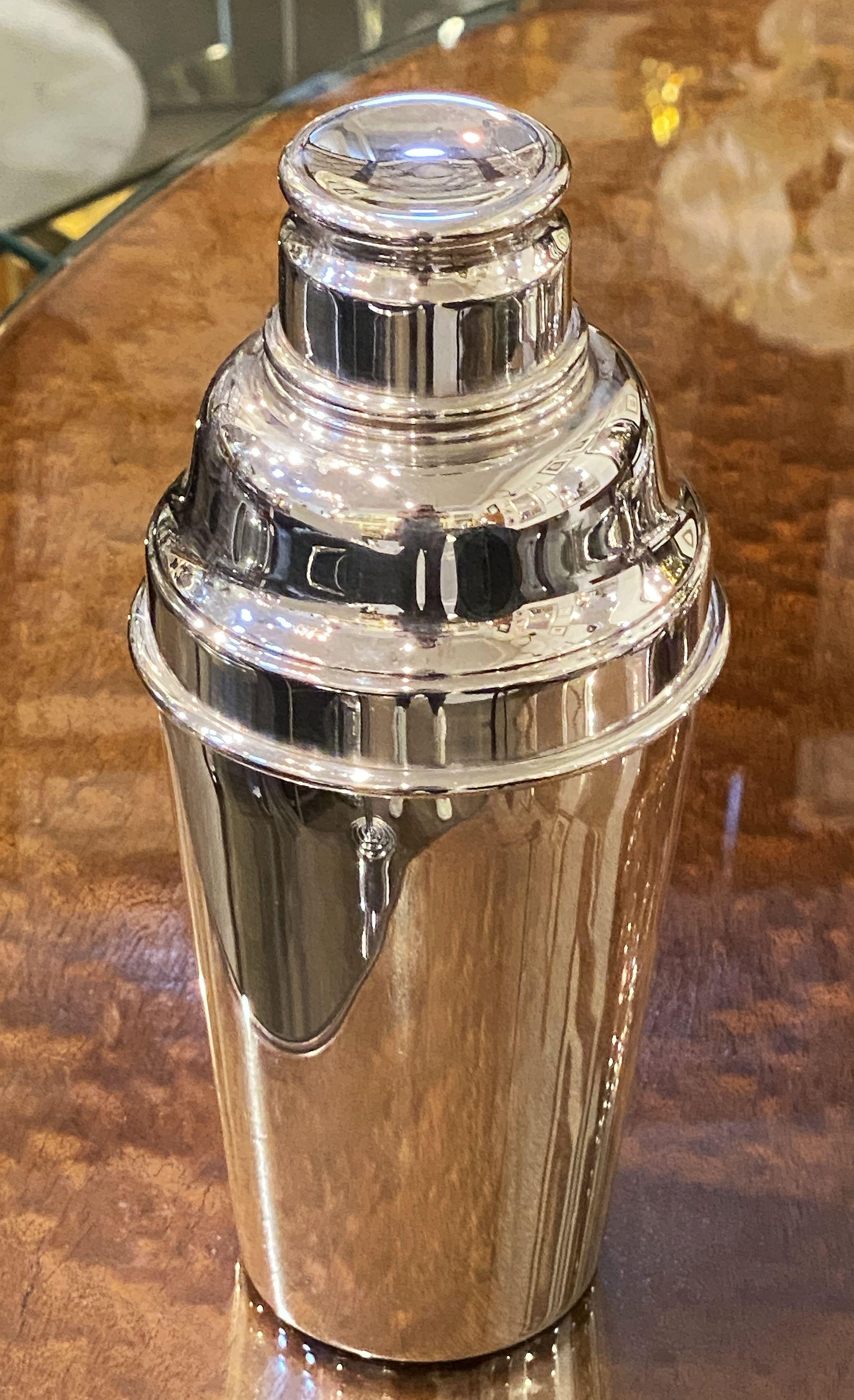 A vintage English cylindrical martini or cocktail shaker of fine plate silver from the Art Deco period, by Angora Silver Plate & Co., with engine-turned removable cap and strainer.

Marked on base: Angora - EPNS - Made in England

Perfect for