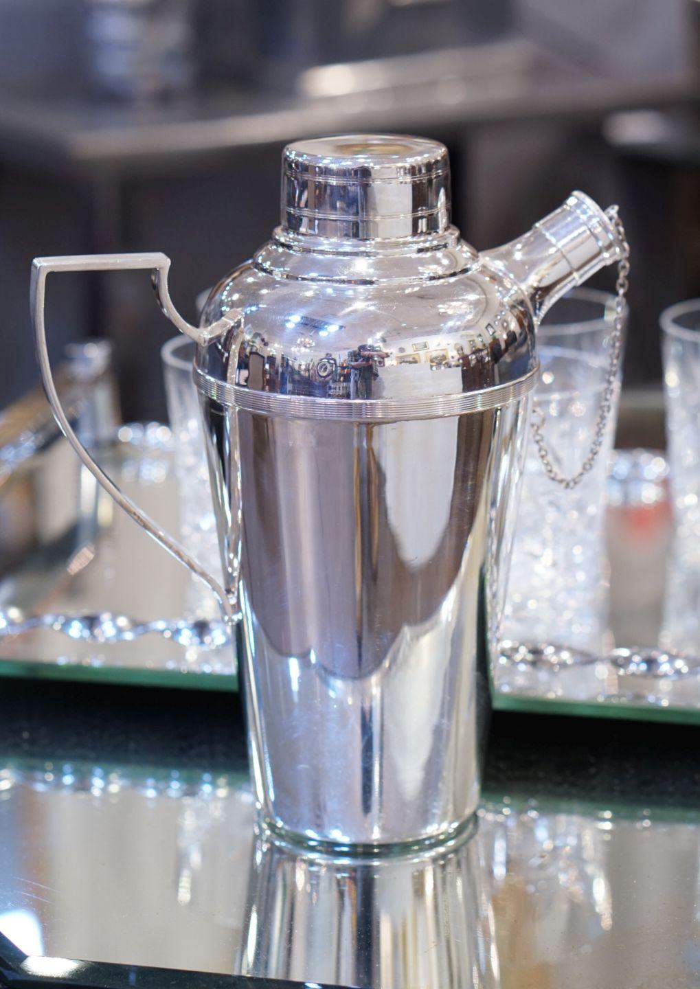 A vintage English cylindrical martini or cocktail shaker of fine plate silver from the Art Deco period, by James Dixon and Sons - with fitted removable cap and pour spout with strainer and fitted cap with chain (captive capped spout) and an angular