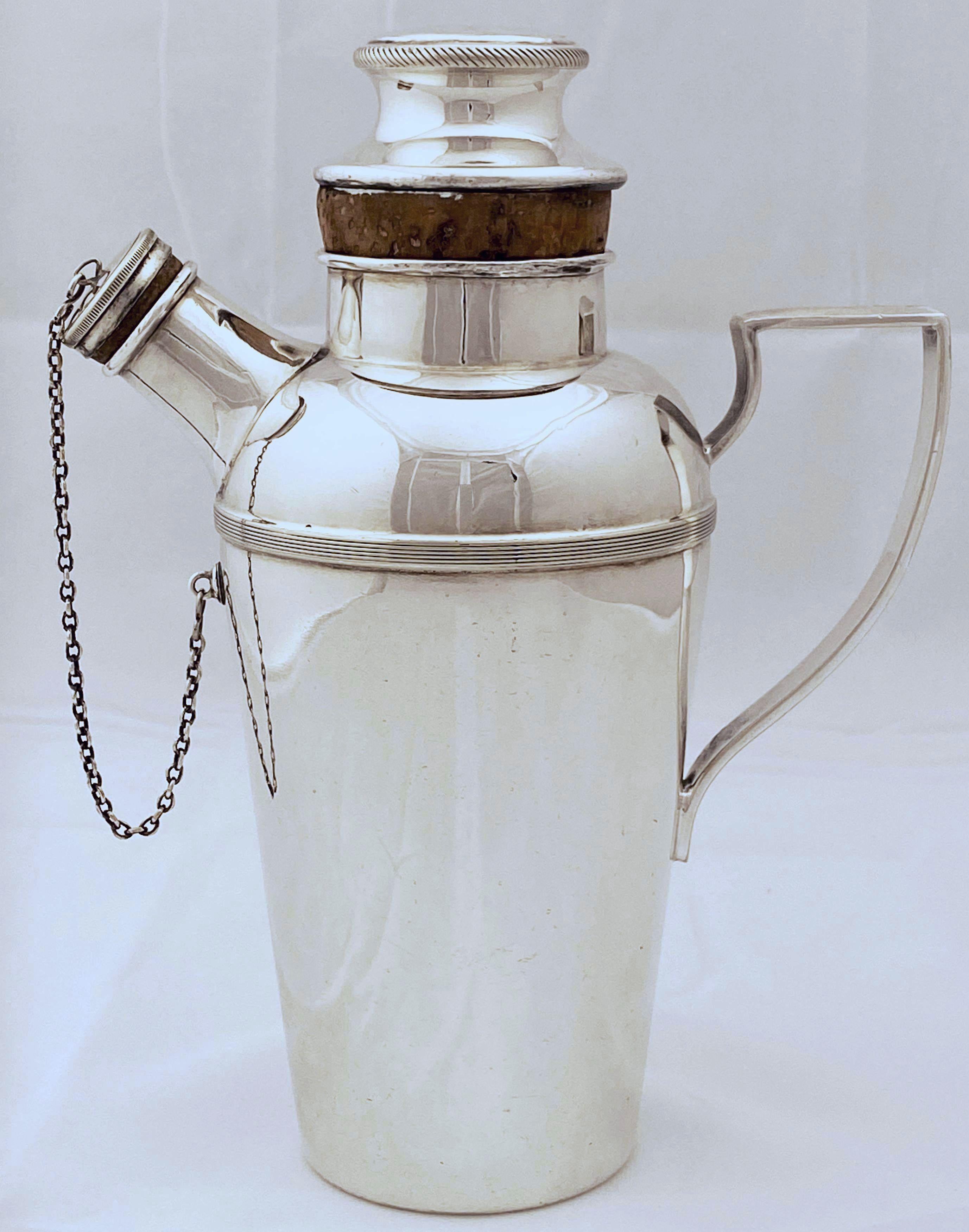 A vintage English cylindrical martini or cocktail shaker of fine plate silver from the Art Deco period, by James Dixon and Sons, with engine-turned removable cap and pour spout with strainer and corked cap with chain (captive capped spout). The cap