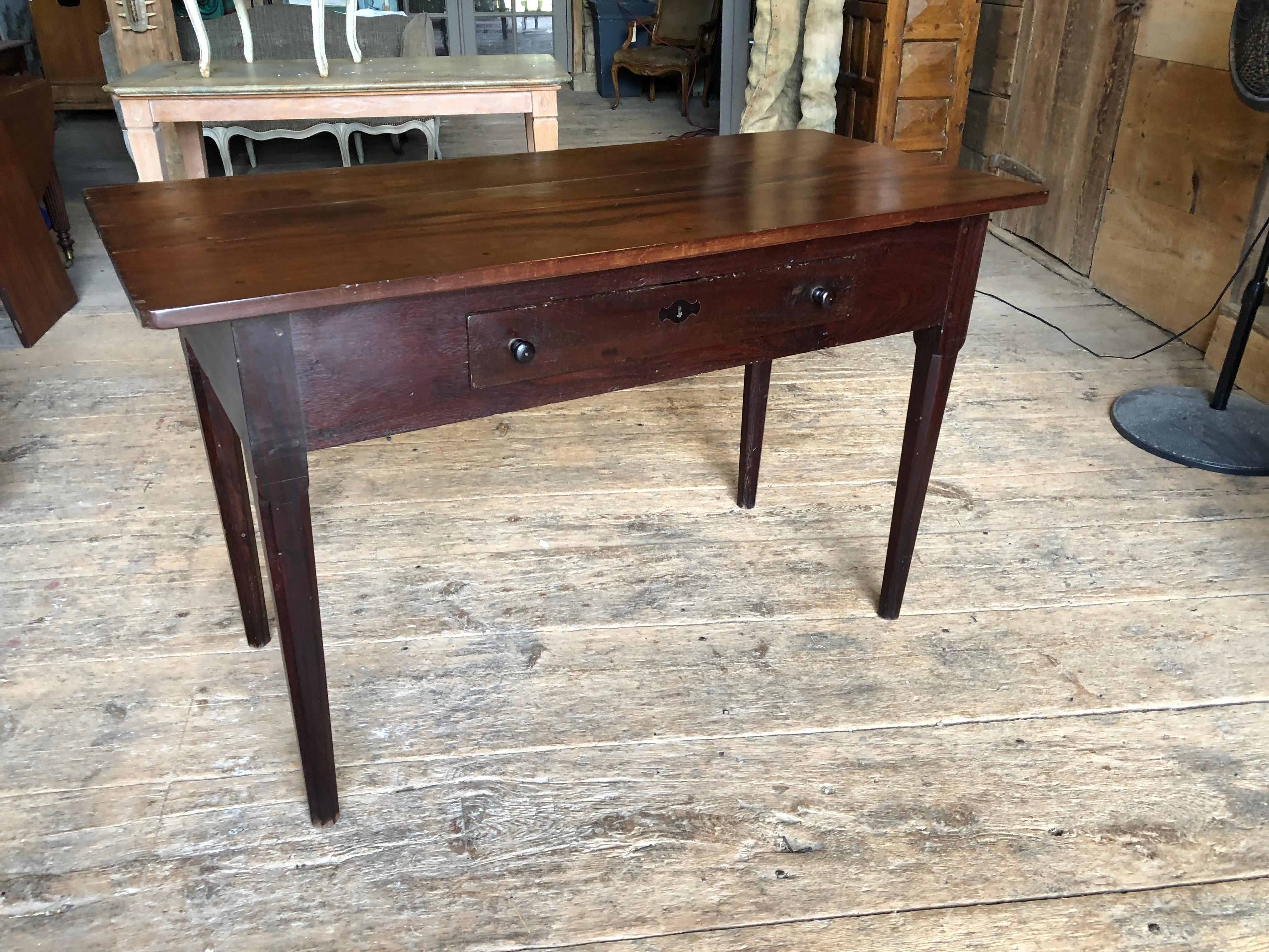A Provincial English Regency period serving table in solid old growth Cuban mahogany, circa 1840, with chamfered legs and a single drawer in the apron.