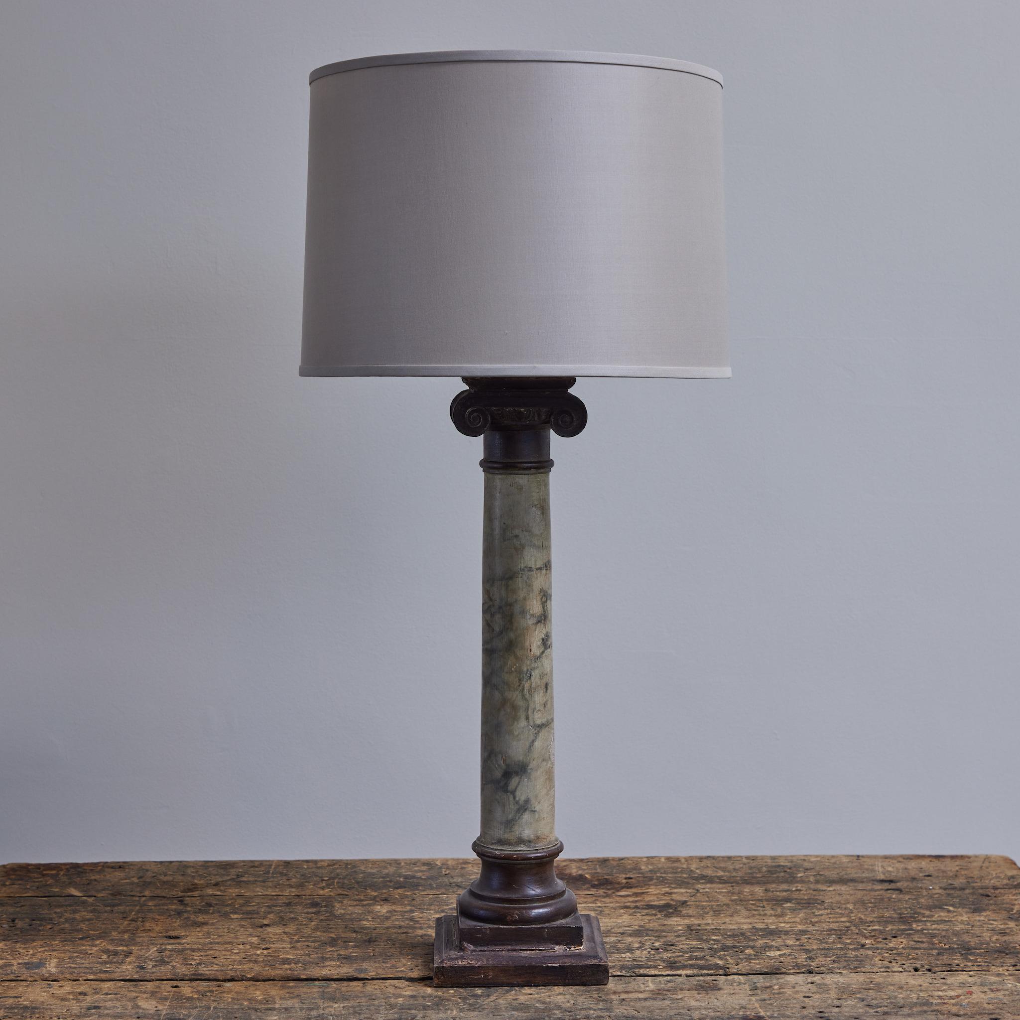 Beautiful late 19th-century English table lamp with custom cream linen drum shade and gray faux-marble hand-painted column base. The effect of the brushwork is an impressive trompe-l'oeil. Offset by the ionic-style capital and pedestal in a dark