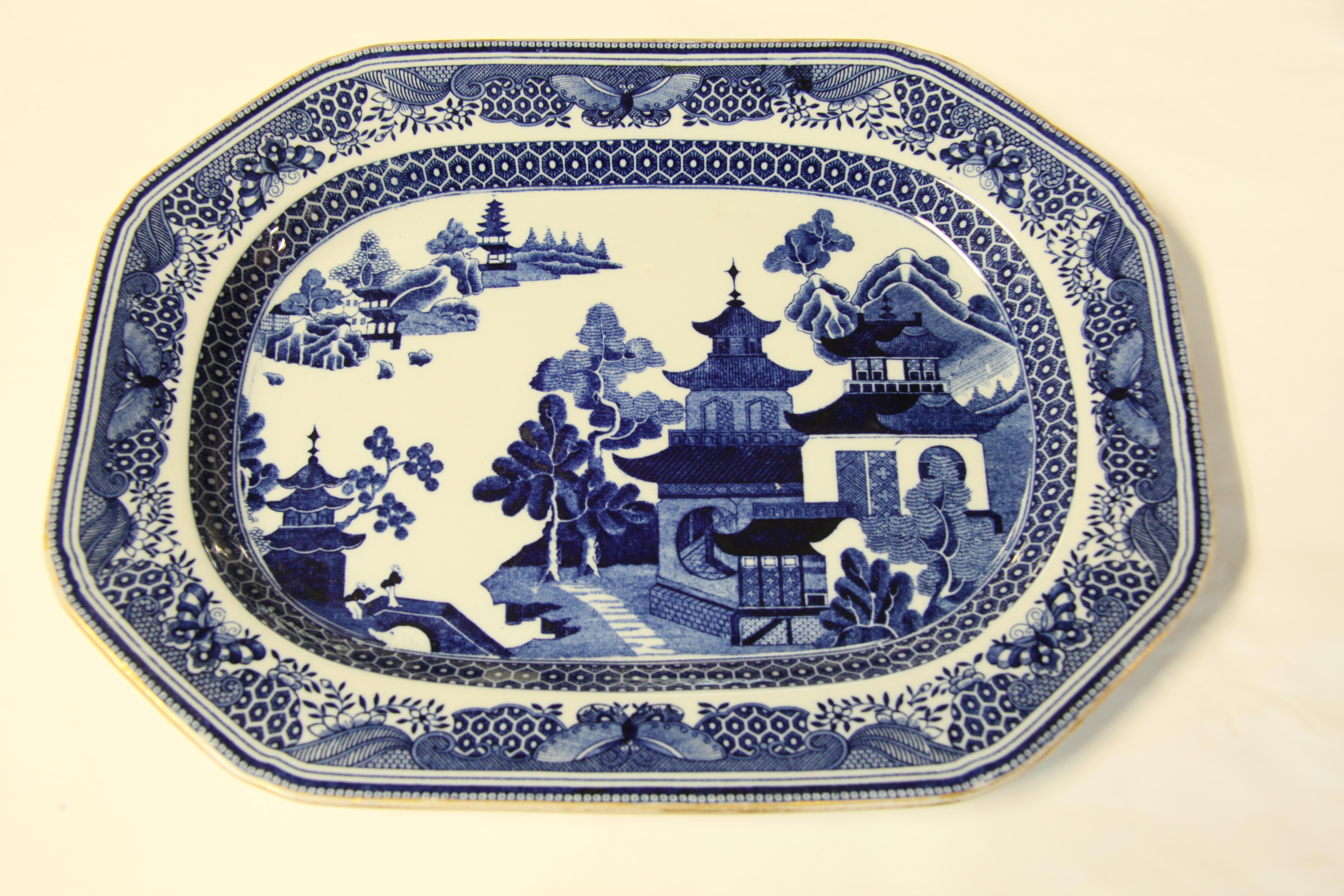 English Copeland Spode blue and white platter, the border inside the gilded edge has a variety of butterflies along with stylized flowers and foliage;  the main body features typical oriental motifs- trees, flowers, bridge, small and large pagodas .