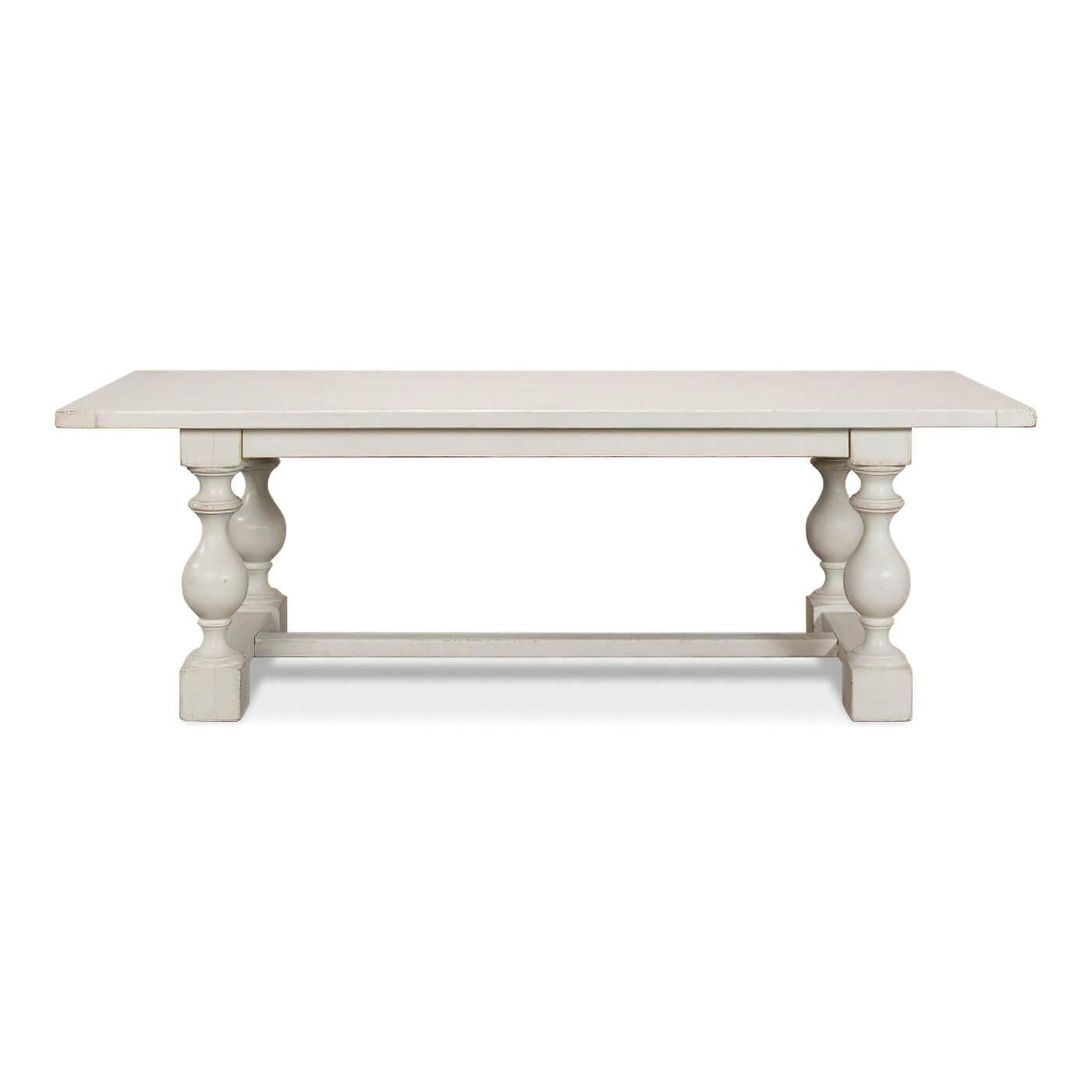 An English Country style antique white dining table with bold shapely turned baluster supports and an H stretcher base. Made of reclaimed pine with a breadboard end plank top.

Dimensions: 94
