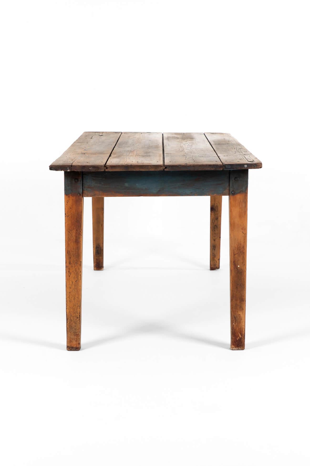 A wonderful English pitch pine farmhouse table.

Generous two-plank top raised on four square legs with traces of original blue paint to the top, apron and legs.

English, circa 1850.

TOTAL

L: 190 CM  L: 74.8 INCHES

W: 79 CM  W: 31.1 INCHES

H: