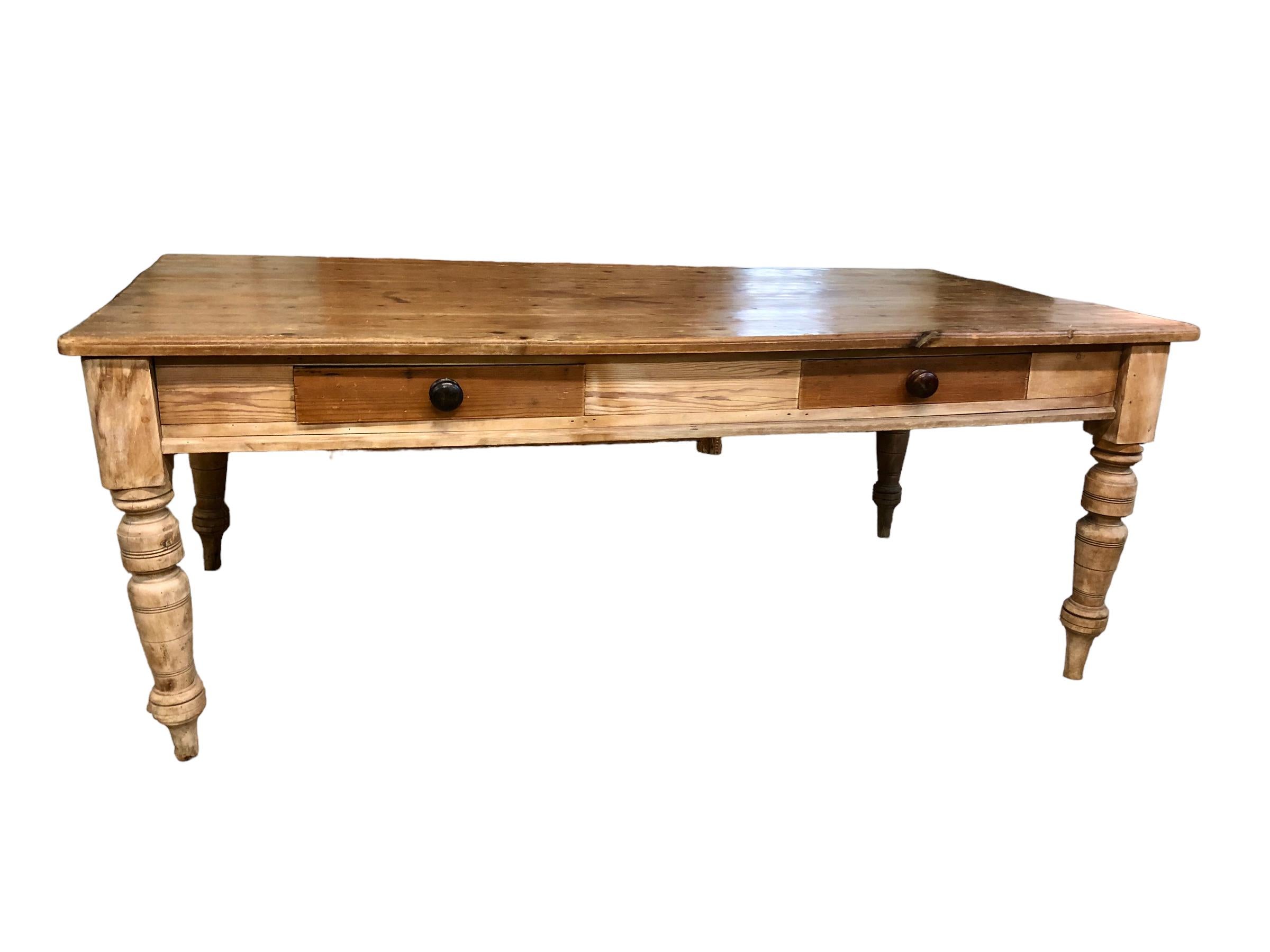 1920’s English Pine two drawers Farm Table. Table has a beautiful thick top that has been hand planed and a wonderful patina. Table is raised on solid turned legs. Each drawer runs almost the entire depth of the table offering lots of storage. This