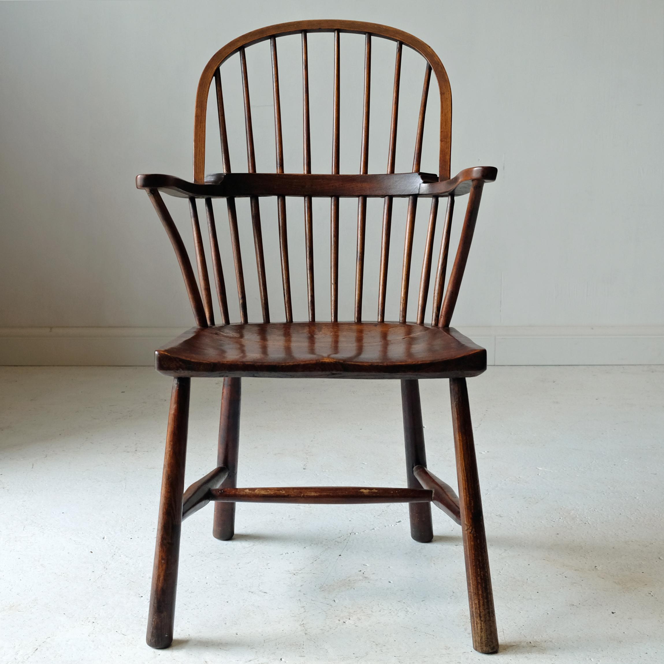 West Country Windsor armchair with simple stick back. Shaped elm seat with ash and beech arms and hand-drawn spindles. Plain tapered legs with H stretcher. Minor evidence of historic woodworm, mainly to legs. Likely Cornish, circa