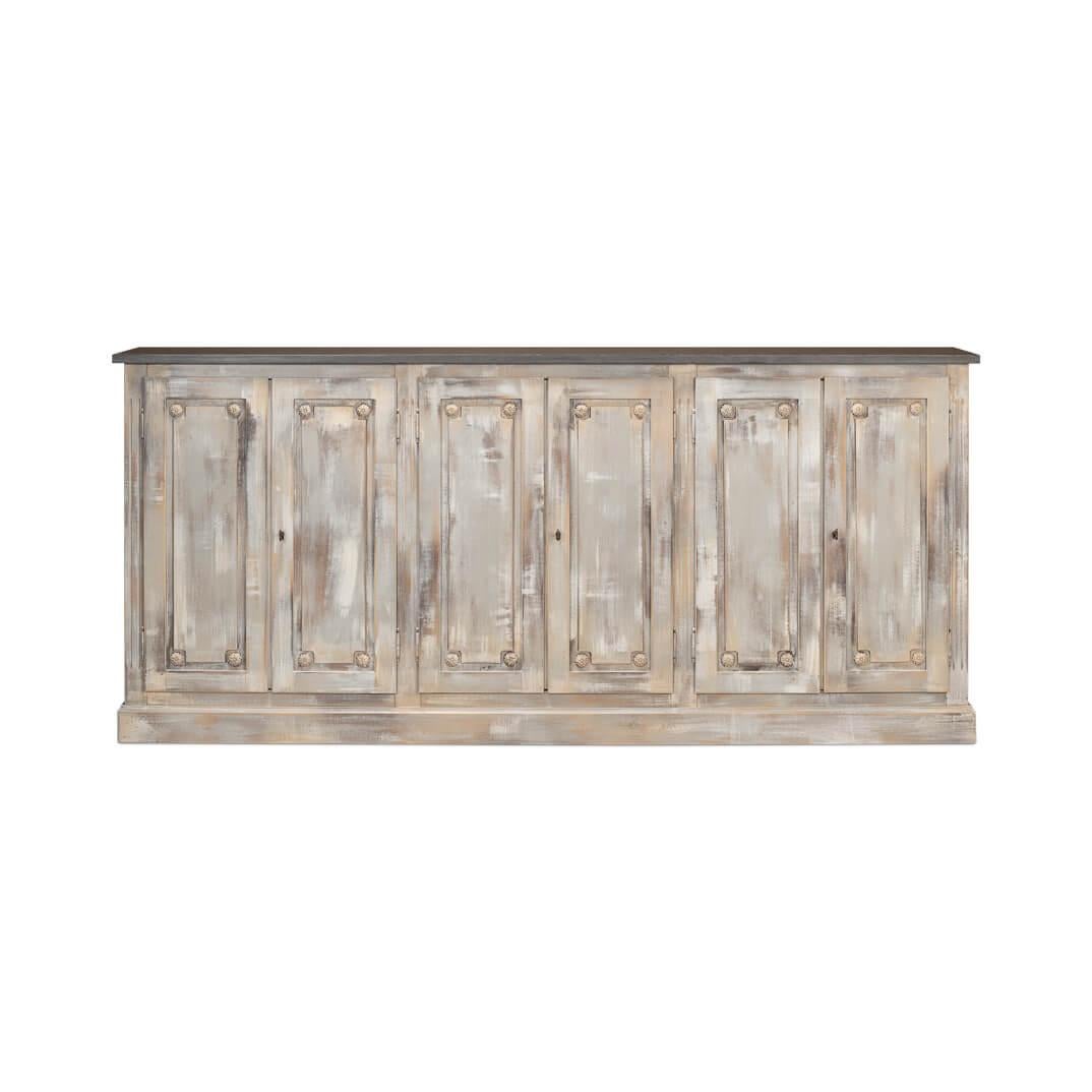With six paneled cupboard doors, each adorned with carved floral rosettes, raised on a simple square plinth base. This substantial piece brings a storied elegance to your dining area or living space.

With a stone gray painted top, the beautifully