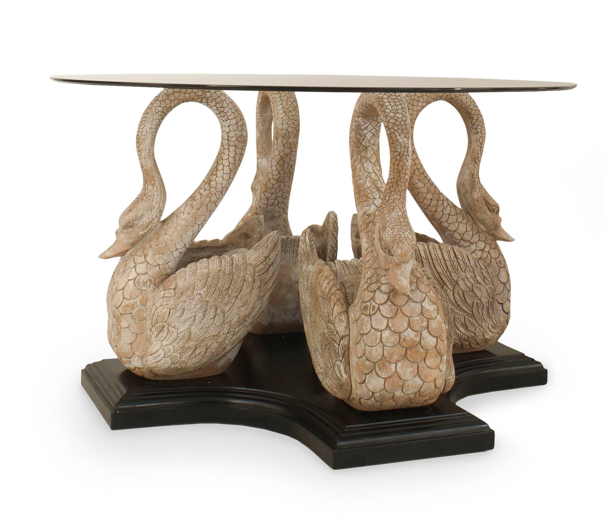 English Country style (19/20th Century) center table with 4 carved and bleached swans resting on an ebonized base supporting a round glass top.
 