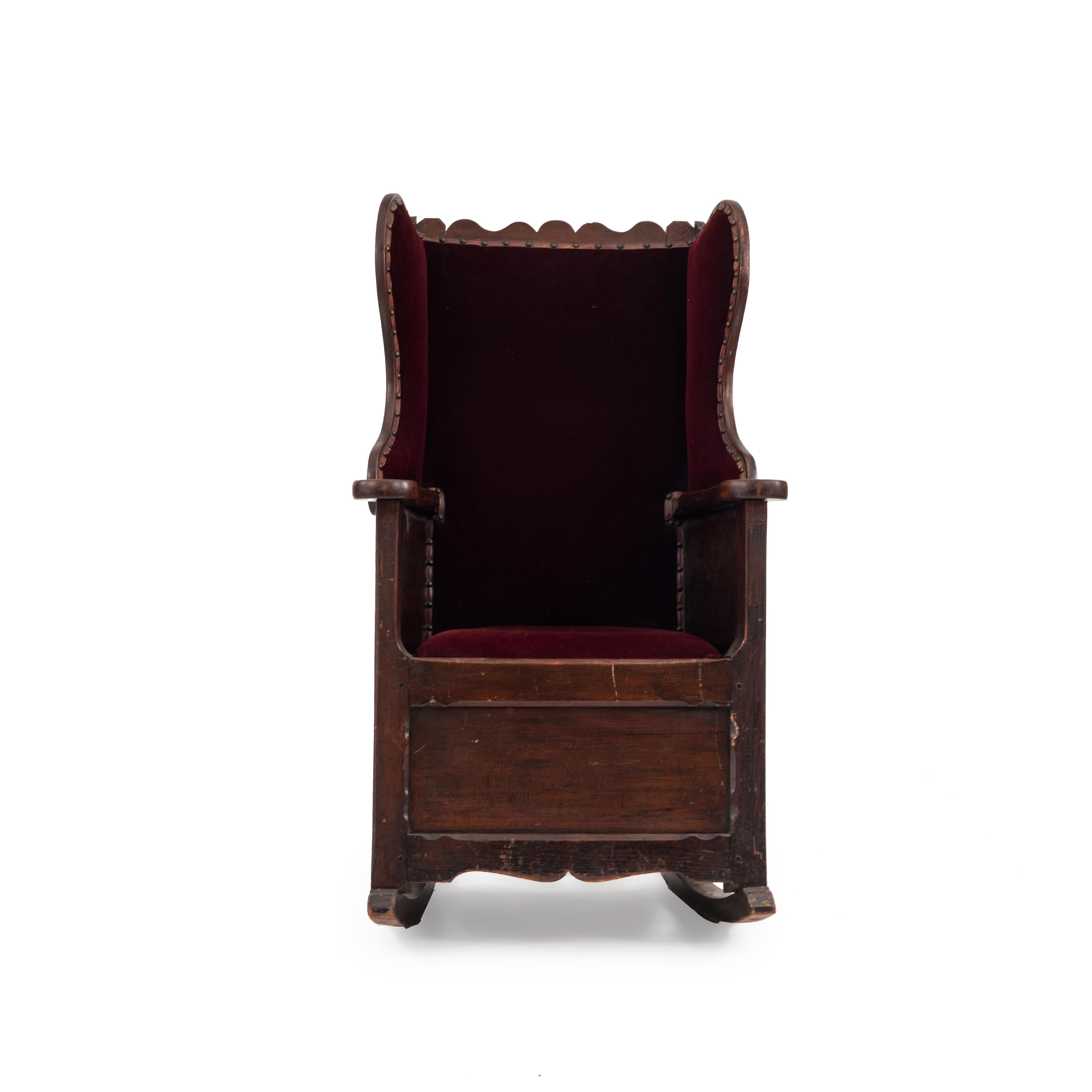 Englischer Landhausstil (18.-19. Jahrhundert), antiker Schaukelstuhl aus Kiefernholz mit geschwungener Rückenlehne und mit rotem Samt gepolstertem Sitz und Rücken.