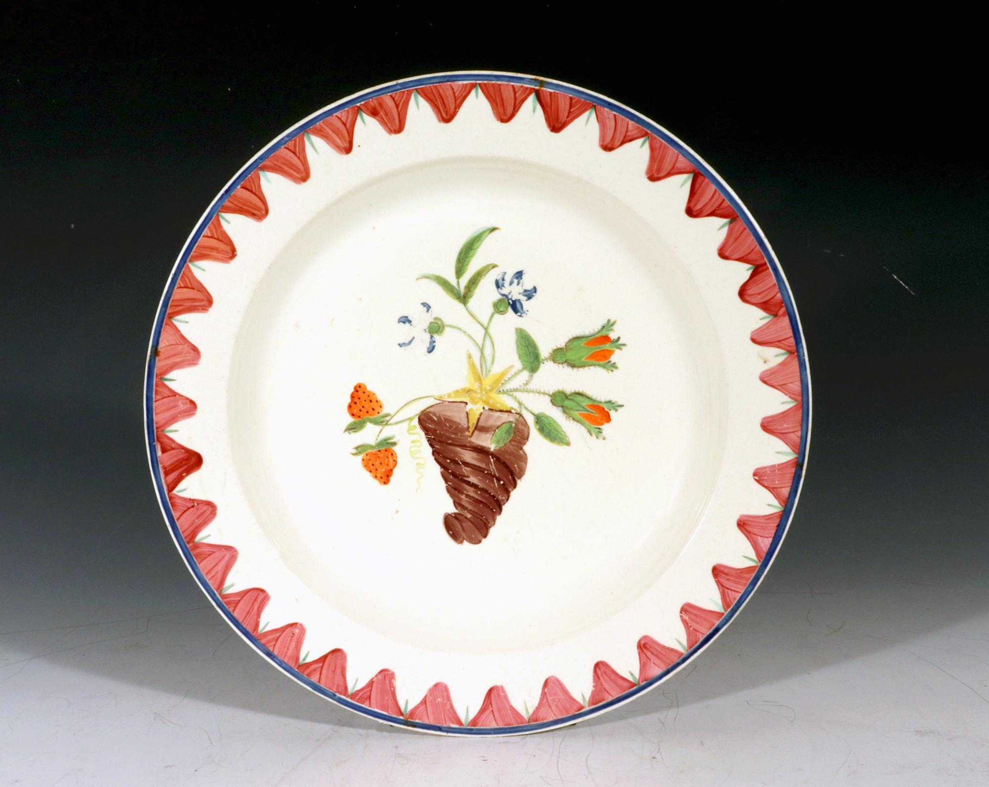 18th Century English Creamware Painted Plate,
Cornucopia of Flowers,
Circa 1780-1800

The circular creamware plat, probably with outside decoration, is painted with a cornucopia shaped vase holding flowers and leaves as well as a strawberry plant in