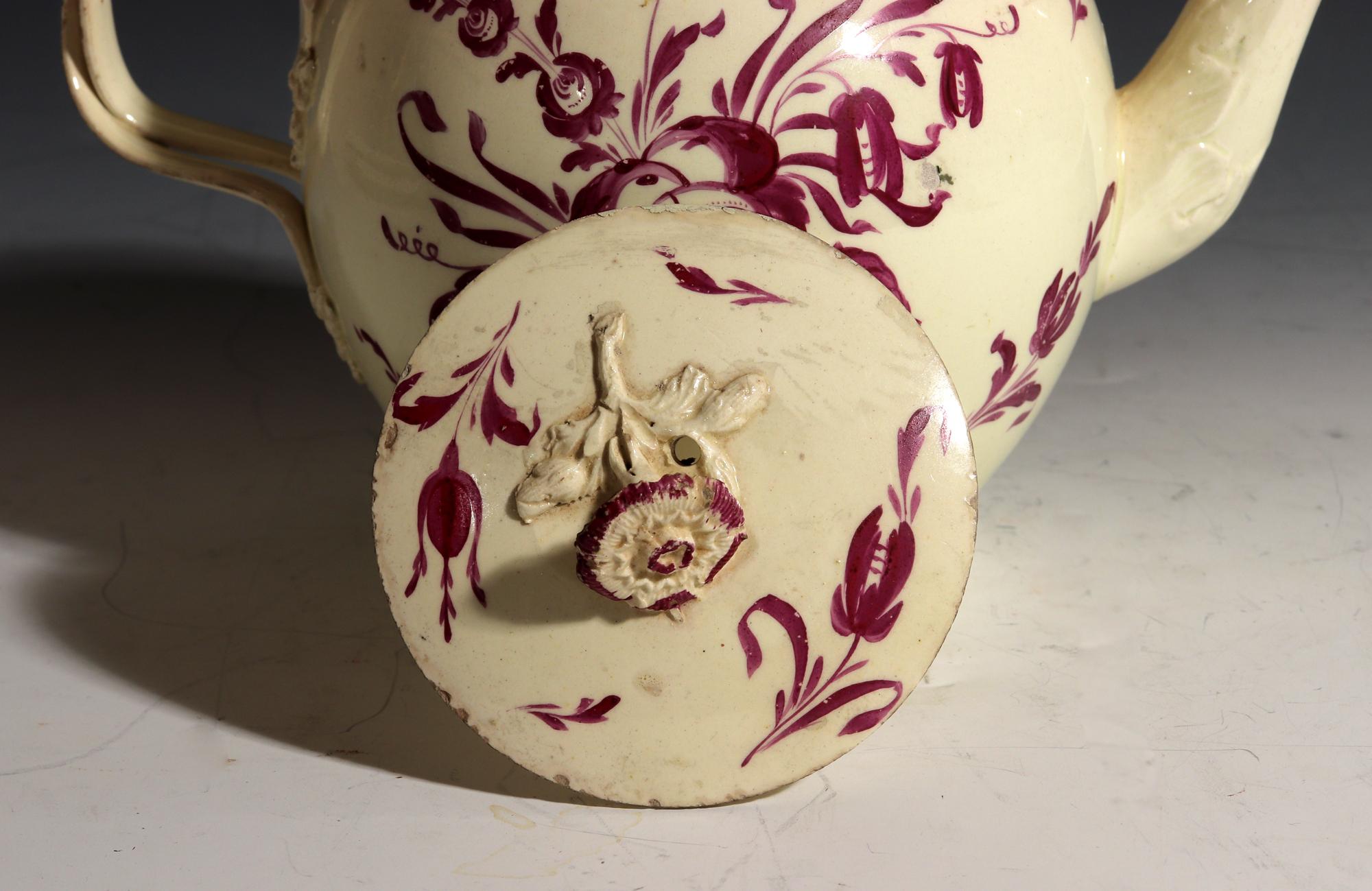 English Creamware Large Teapot with Puce Flower Painted Decoration,
circa 1770

 The Staffordshire Globular teapot is painted with large puce-colored flowers with a bouquet to each side, and other scattered leaves on the sides and the cover. The