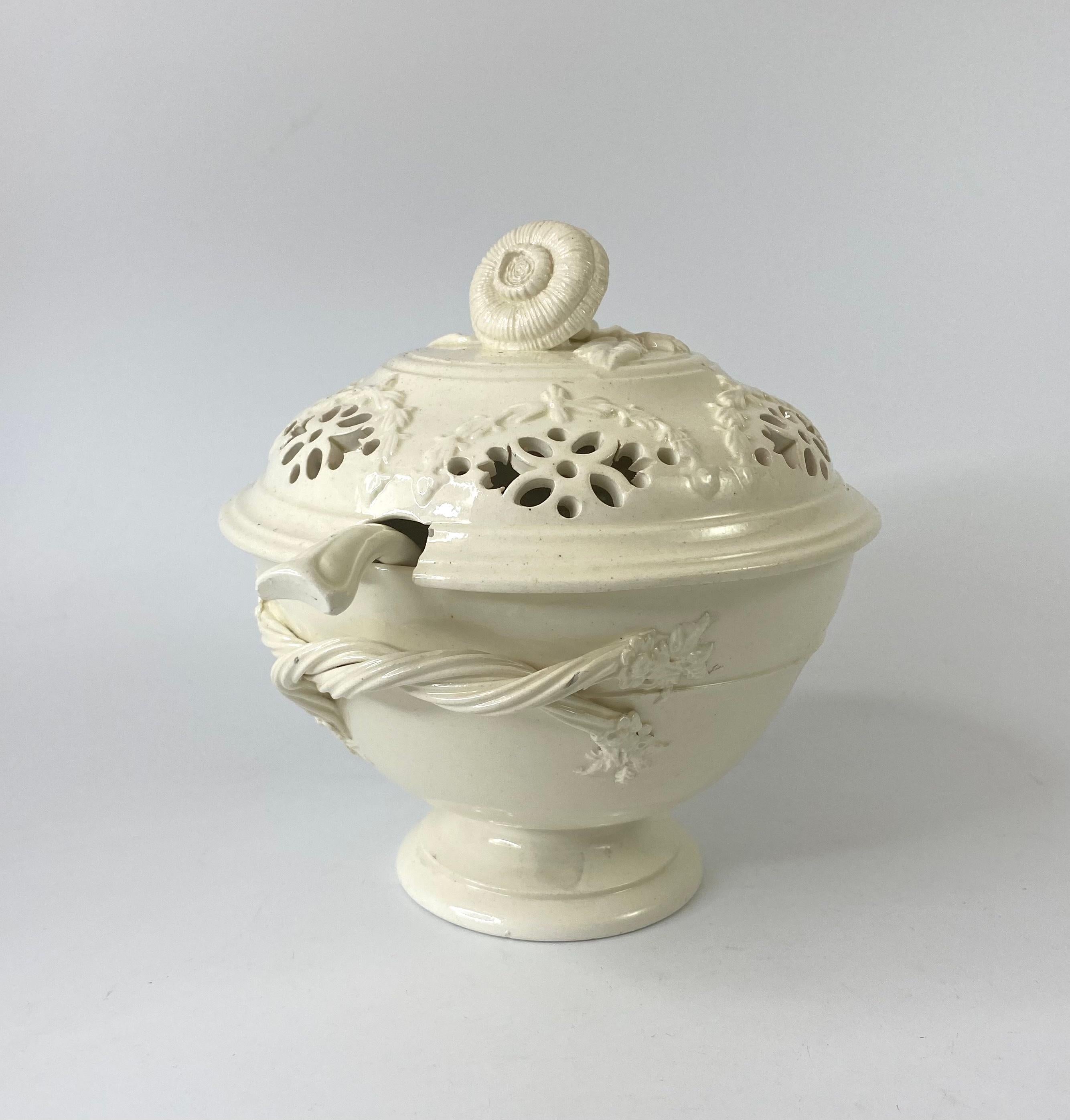English creamware tureen, cover, ladle and stand, c. 1790, probably Yorkshire. The tureen having rope twist handles, terminating with flowers and leaves, standing upon a pedestal footrim. Having a pierced cover, moulded with floral swags, and