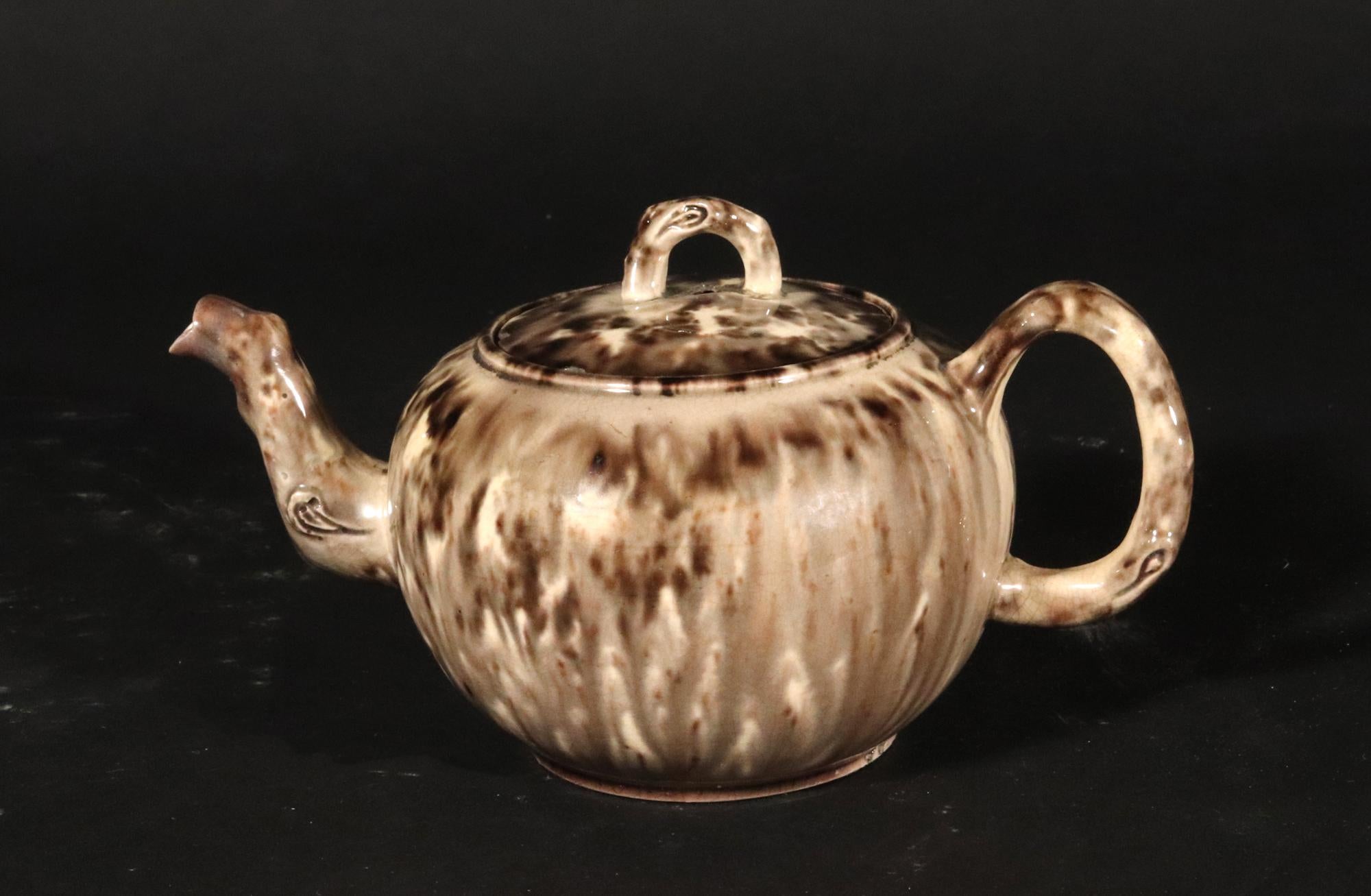 Théière et couvercle en poterie anglaise Creamware Gray Tortoiseshell Lead Glaze,
Whieldon Type,
Circa 1765.

La théière et le couvercle en creamware, de petite forme circulaire, sont décorés d'une glaçure à l'écaille de plomb inhabituellement