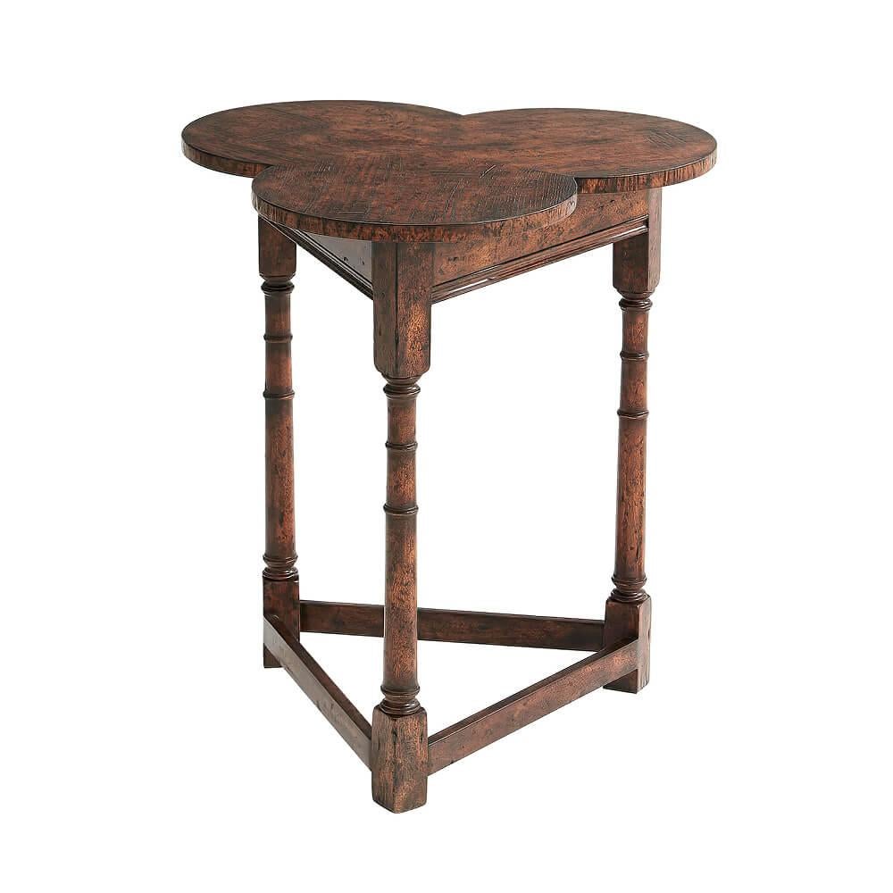 A mahogany and reclaimed oak 'Clover' table, the trefoil top above a triangular frieze and Cricket base, on three turned and block legs joined by board stretchers.
Dimensions: 24.5