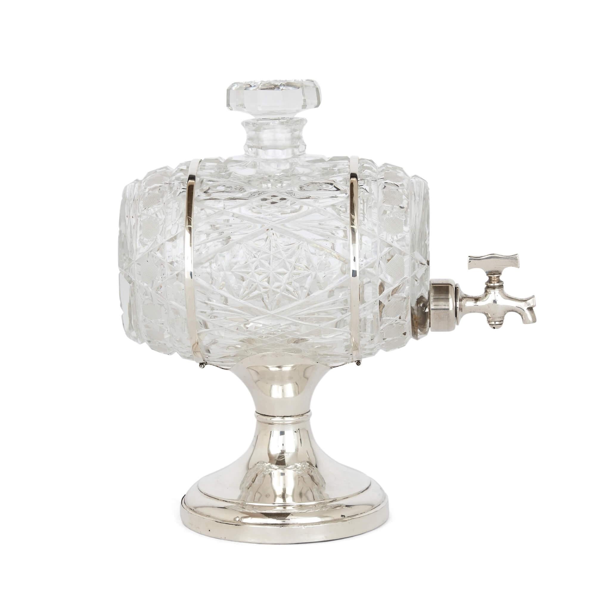 English crystal and silver barrel decanter
English, 1929
Measures: Height 26cm, width 12cm, depth 24cm

This wonderful decanter is modelled as a barrel, replete with tap to empty its contents. The body of the barrel is crafted from cut crystal,