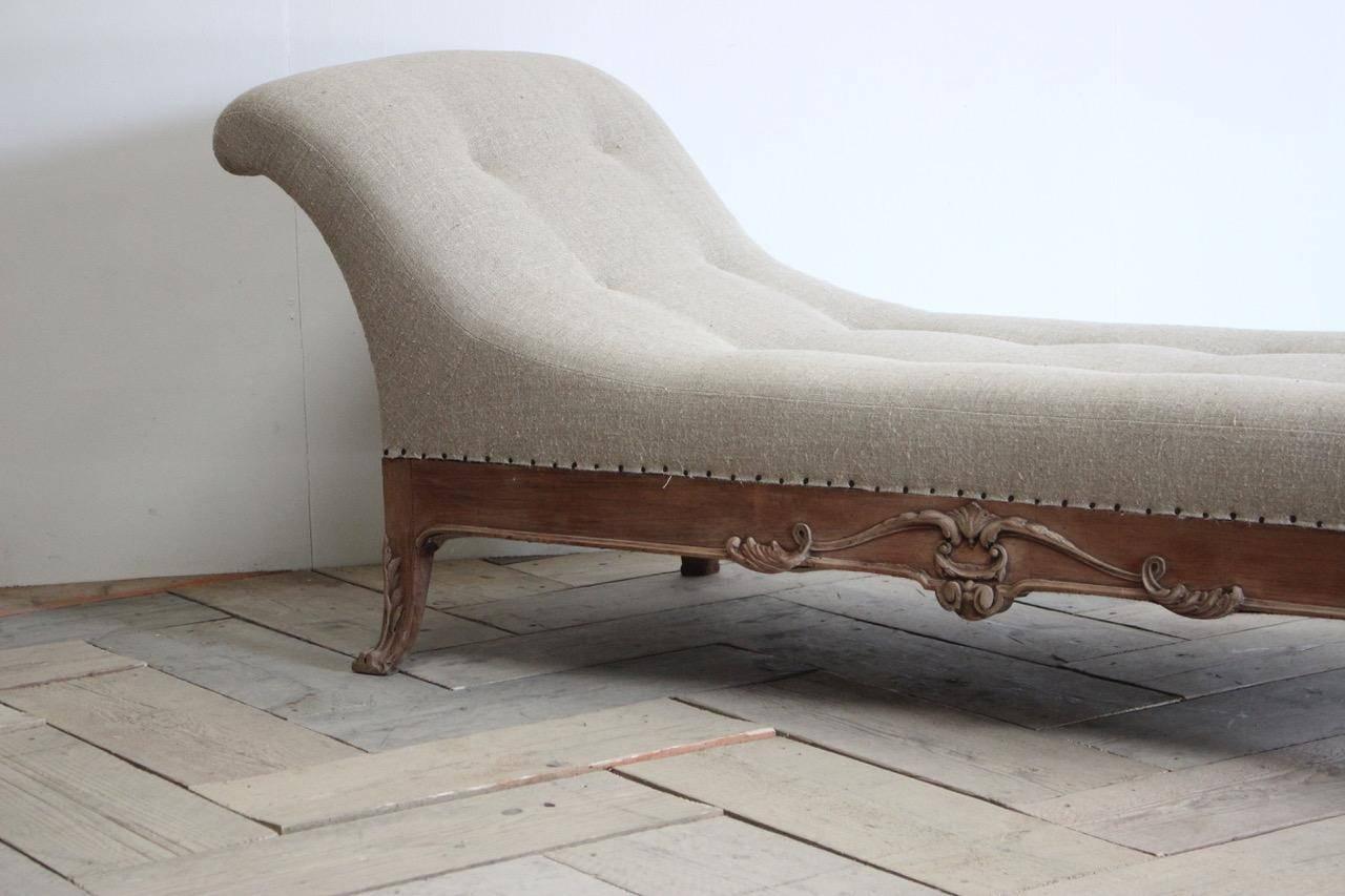 A very elegant and recently reupholstered in neutral linen, late 19th-early 20th century English daybed in bleached mahogany, with lovely detail, that will work well in most settings.