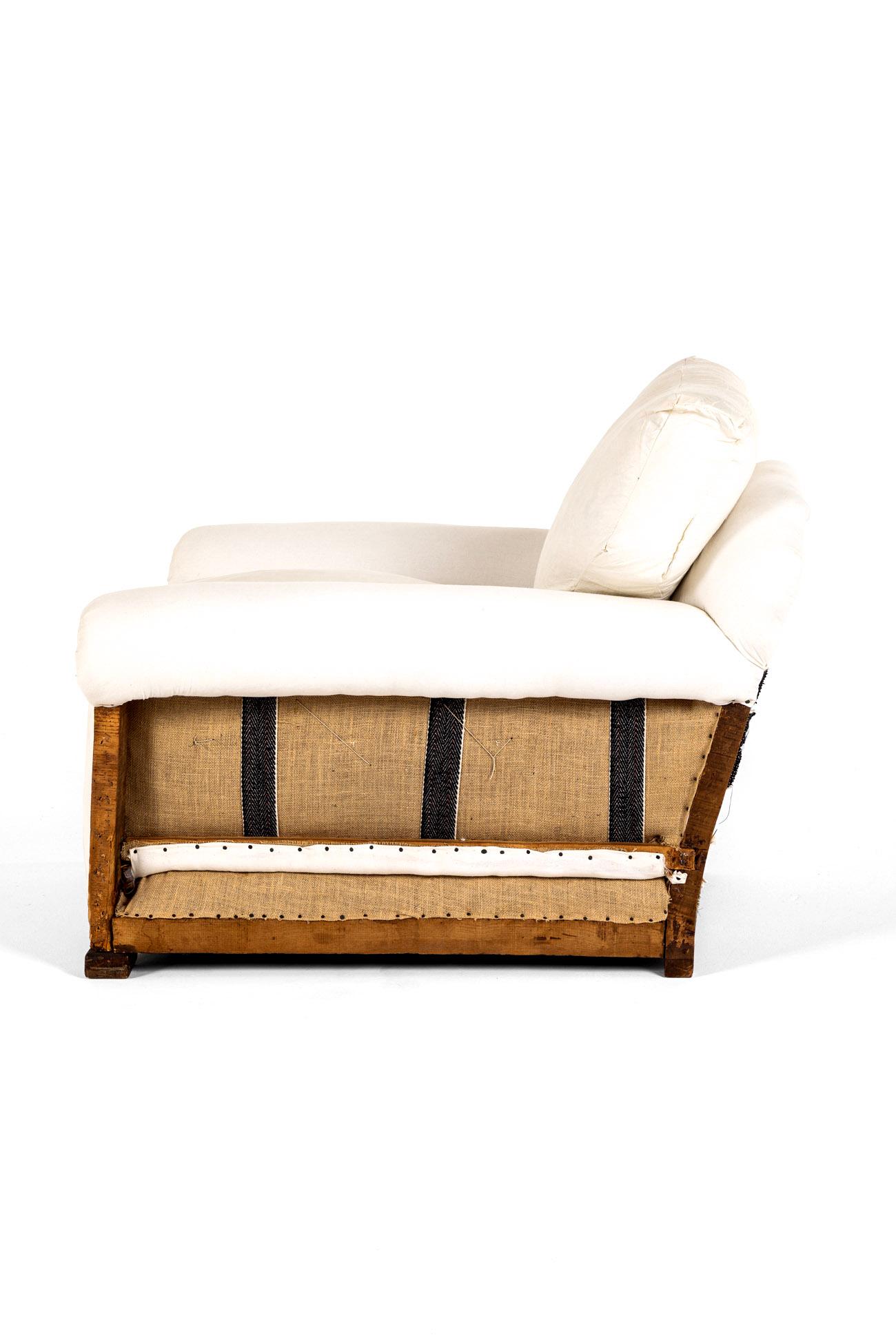 A deconstructed Howard and Sons style low armchair with a deep seat and shapely wide back and generous gently scrolling arms.

The armchair has been fully restored and stripped back to the solid oak frame for upholstery with a refurbished coil