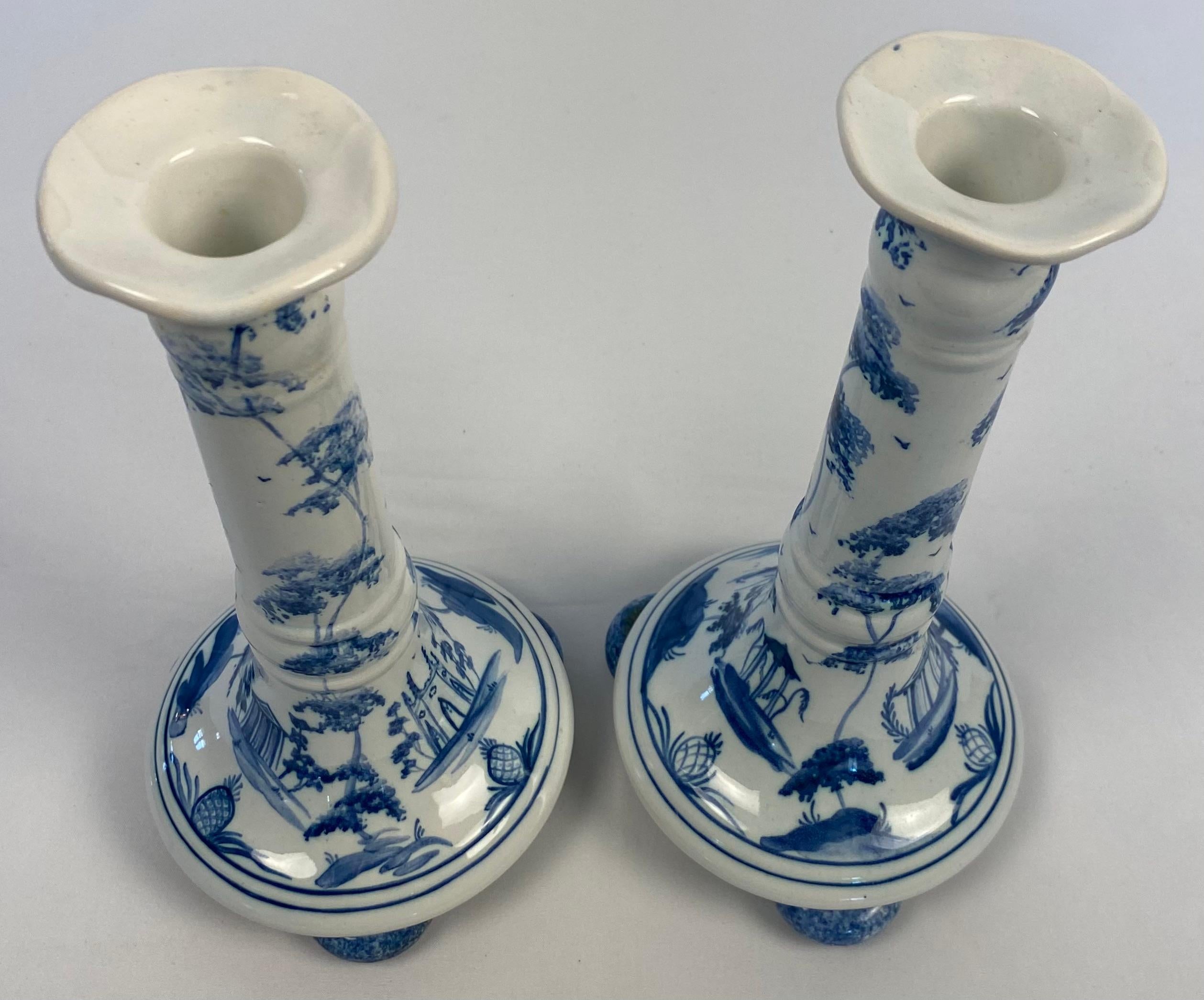 A fine pair of blue and white Delft porcelain candle holders. 
Crafted in England.
 
Decorated with floral motifs and embellished with traditional decor.
Excellent condition and are stamped on the bottom for further authentication.
Measures: 8 3/8