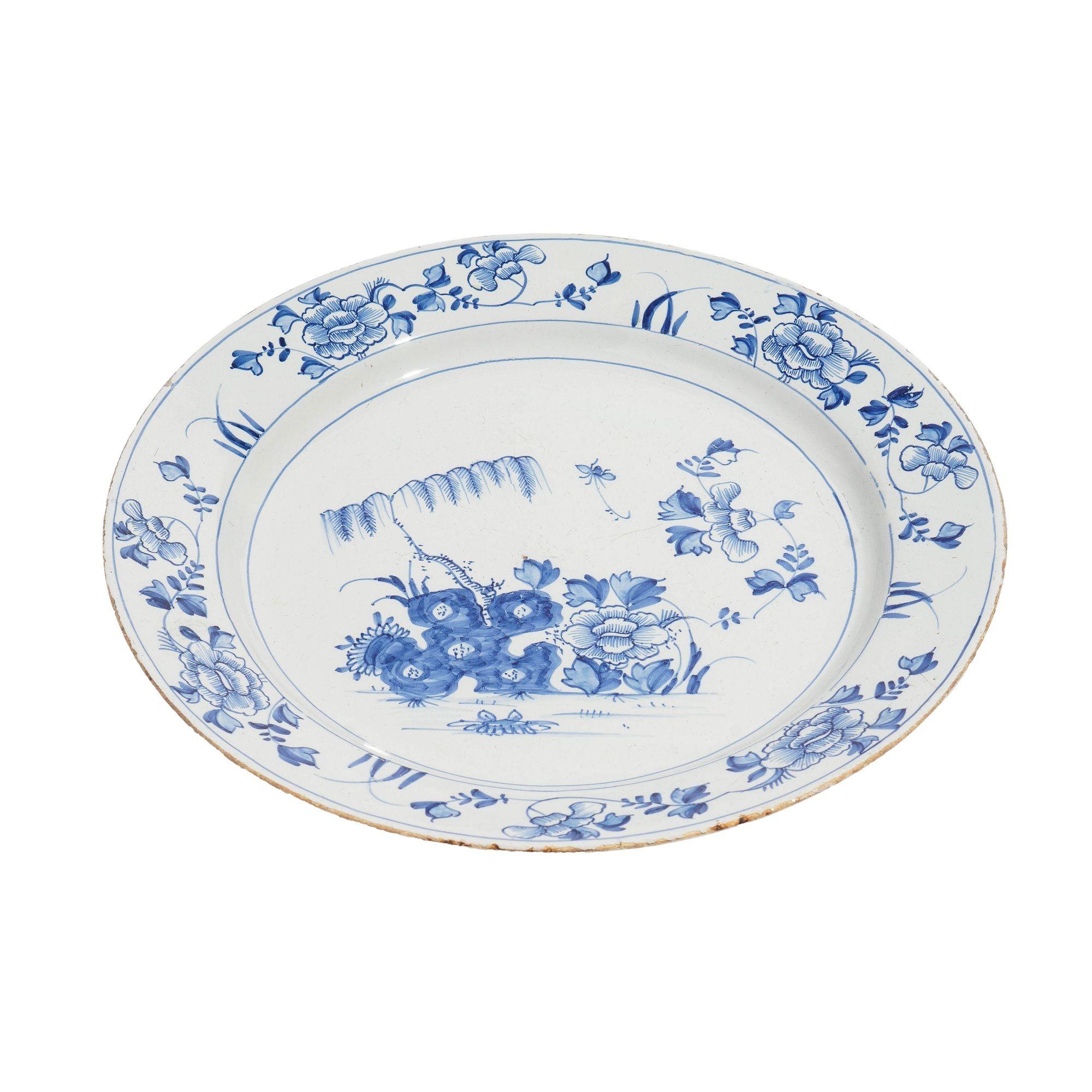 Cargador Bristol Delft con decoración de cobalto de tema floral, con el borde inferior marcado con una serie de ocho marcas alternadas.
El borde está sin esmaltar y una parte de la base se ha roto, pero no afecta a la estabilidad.

Bristol,