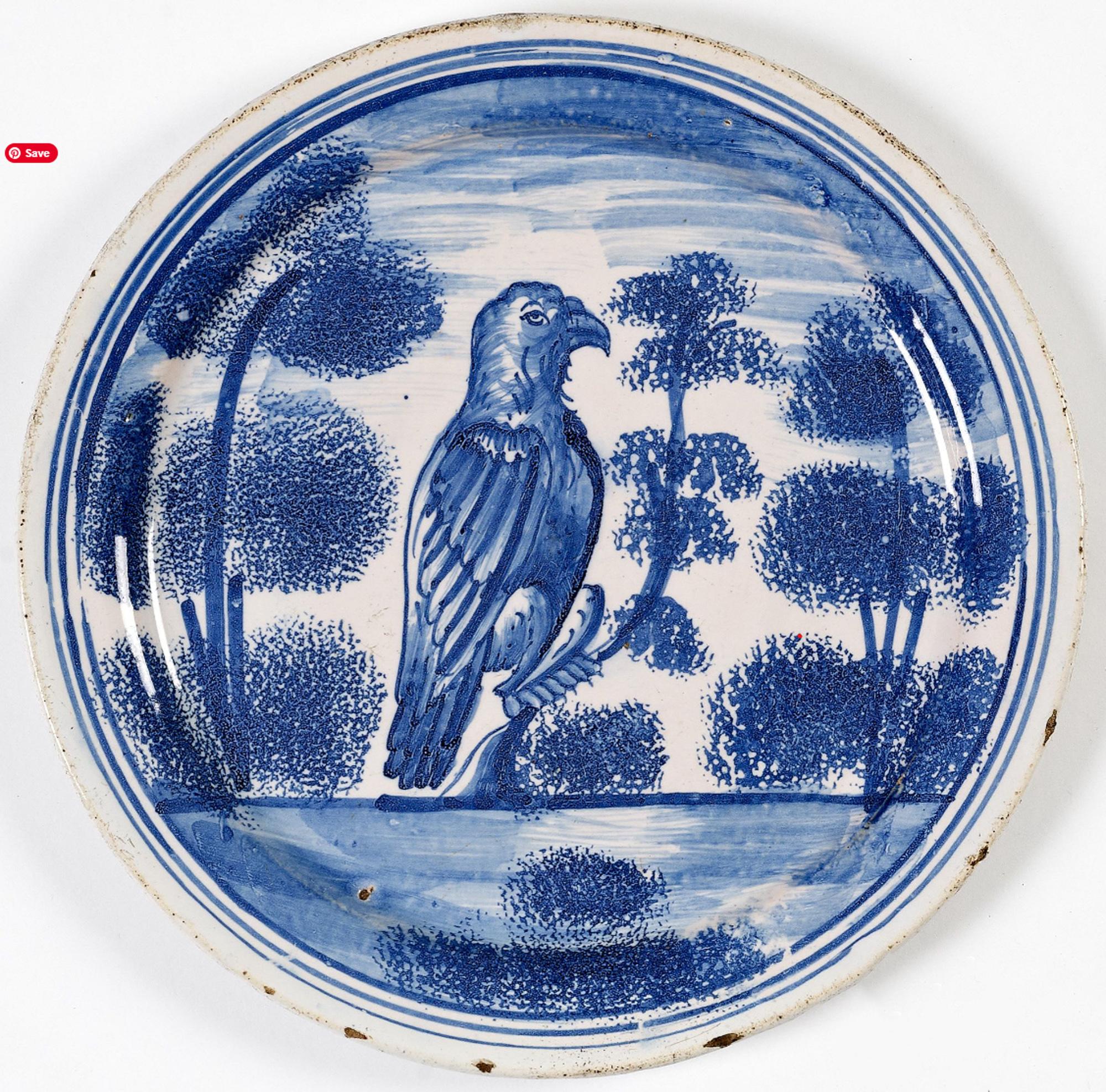 English Delftware Plate with Hawk Perched on Tree, 
London,
Probably Vauxhall,
Circa 1710-25

The circular plate  is painted and sponged.  It depicts a large hawk perched in a tree with other tree to each side.  The border has concentric blue lines