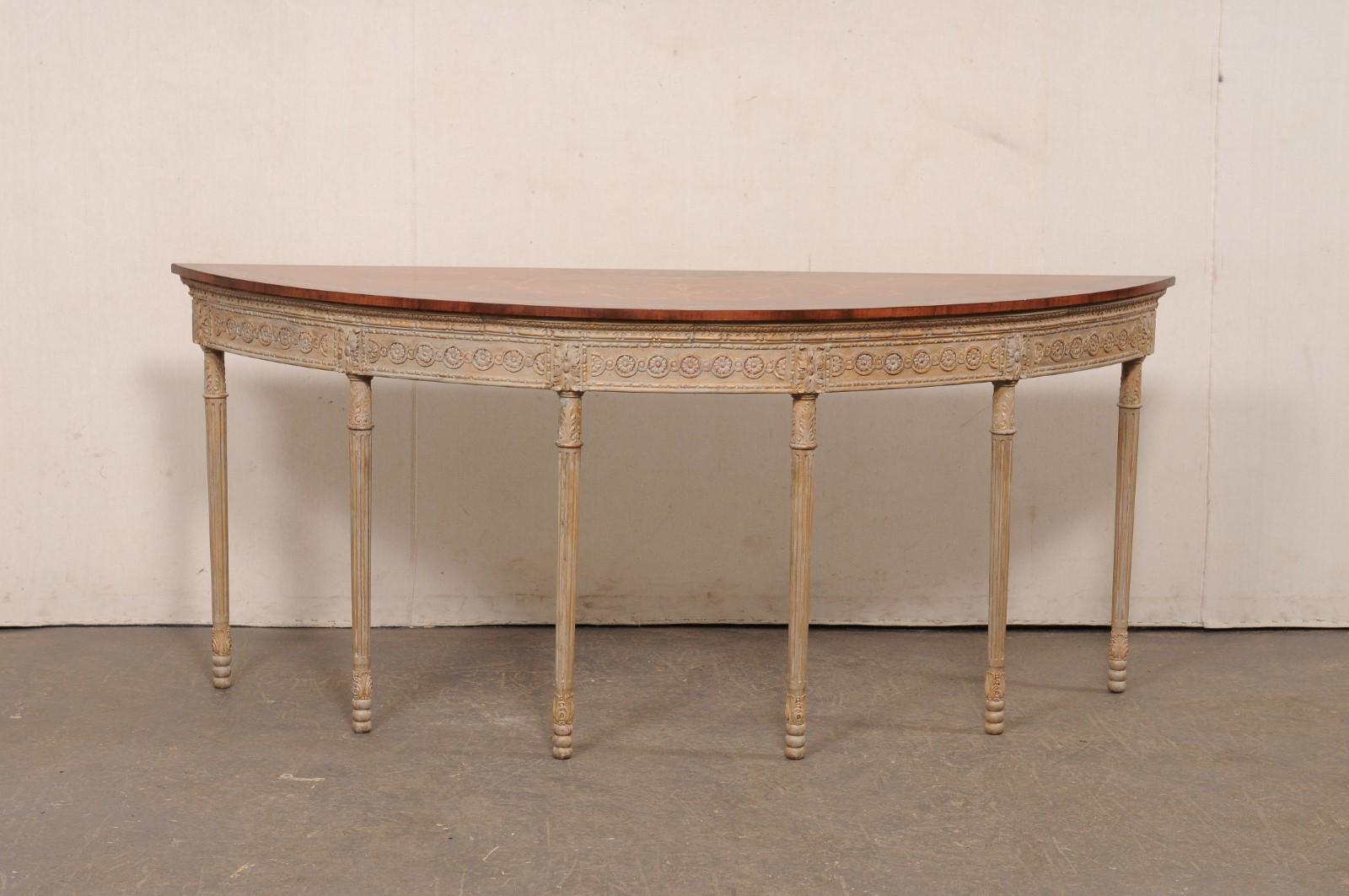 A large-sized English carved-wood demi-lune console table with beautifully decorative top. This vintage table from England features a half-moon top with carved apron decorated in a rhythmic display of repeating circles with flower head centers