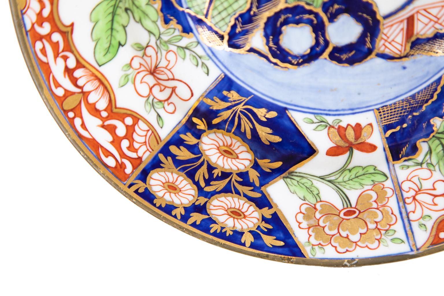 English derby plate, with an over glaze crown mark and is decorated with brilliant cobalt, red, and green floral patterns. There are bold gilt highlights.