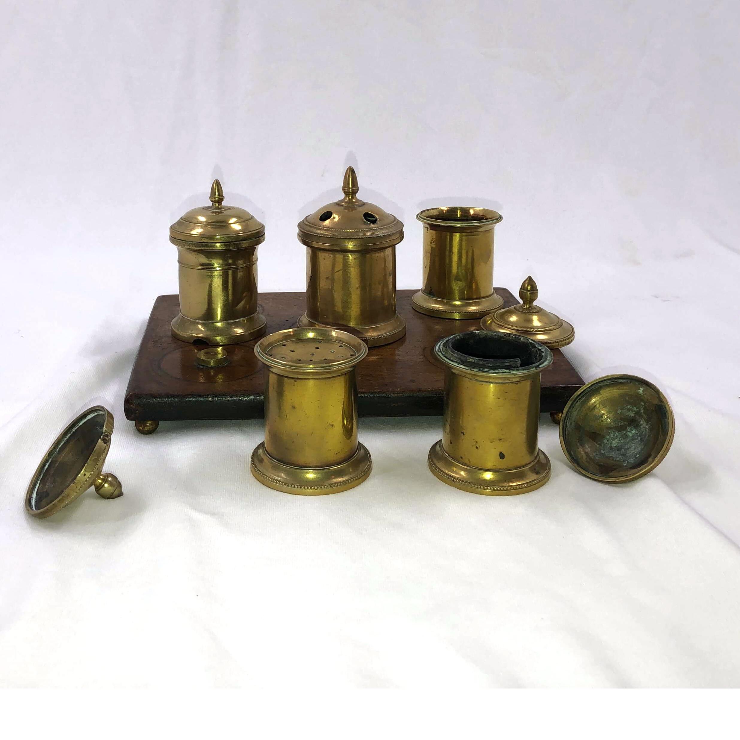 An early English Queen Anne brass inkwell desk set with a walnut base on brass feet.