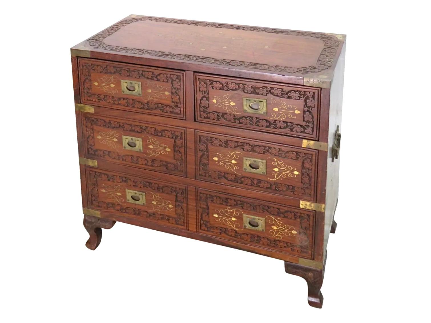 Carved campaign style brass inlaid chest.
Measures: 22.5