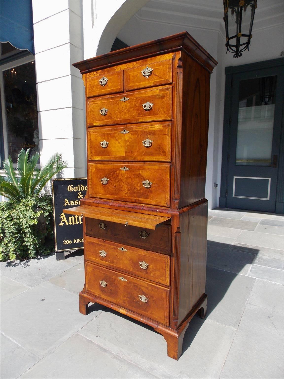 English diminutive burl walnut George I style chest on chest with a carved molded edge cornice, five uppercase graduated drawers, herring bone inlay , fluted corner columns, original cotter pin brasses and escutcheons, book matched veneered side