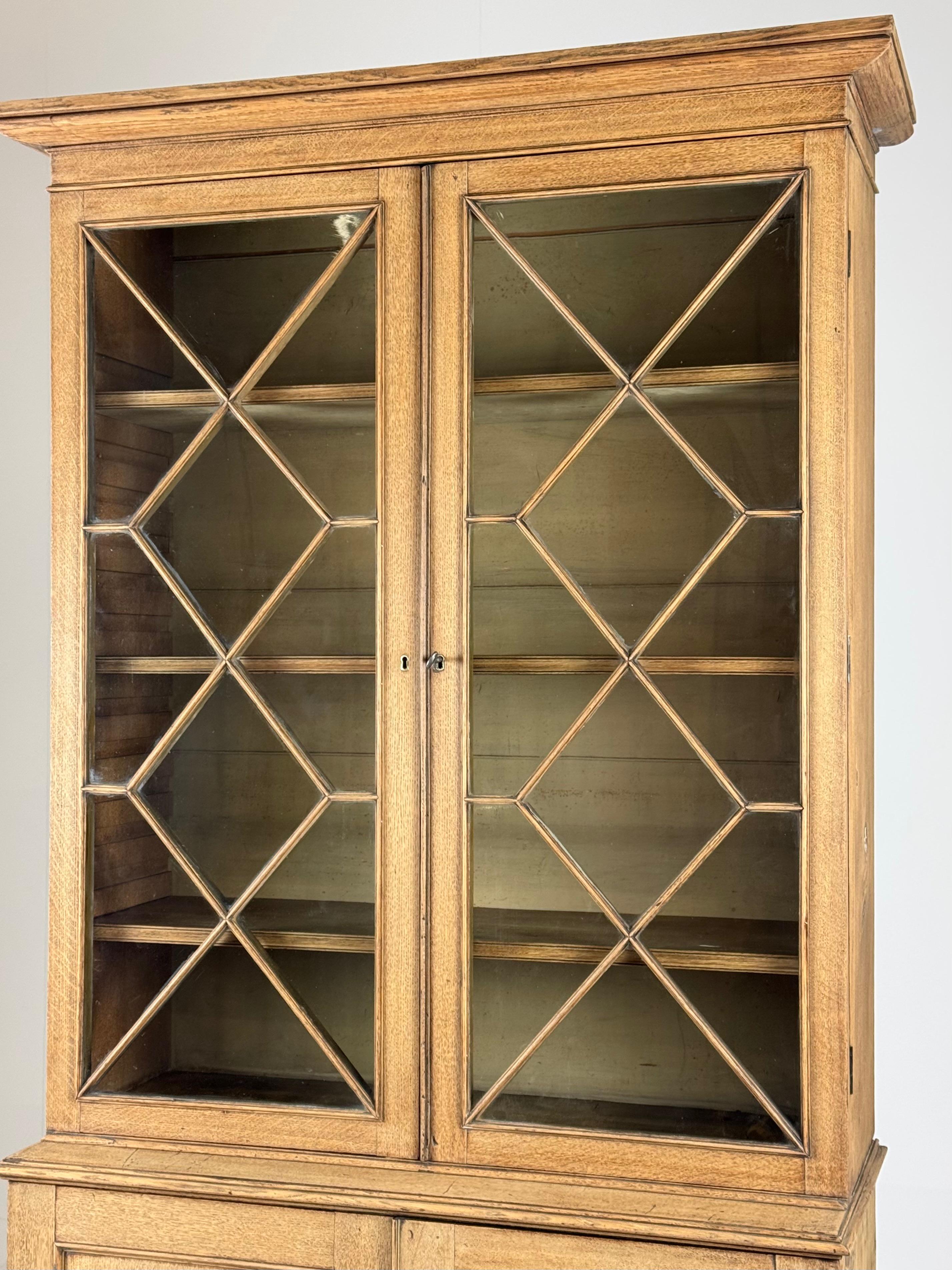 Beautiful clear oak display case / bookcase / sideboard. Original from England, 19th century. Made of oak wood.

In very good condition. Locks working properly. Glass intact. Adjustable shelves. Lower cabinet has multiple drawers with brass hardware.