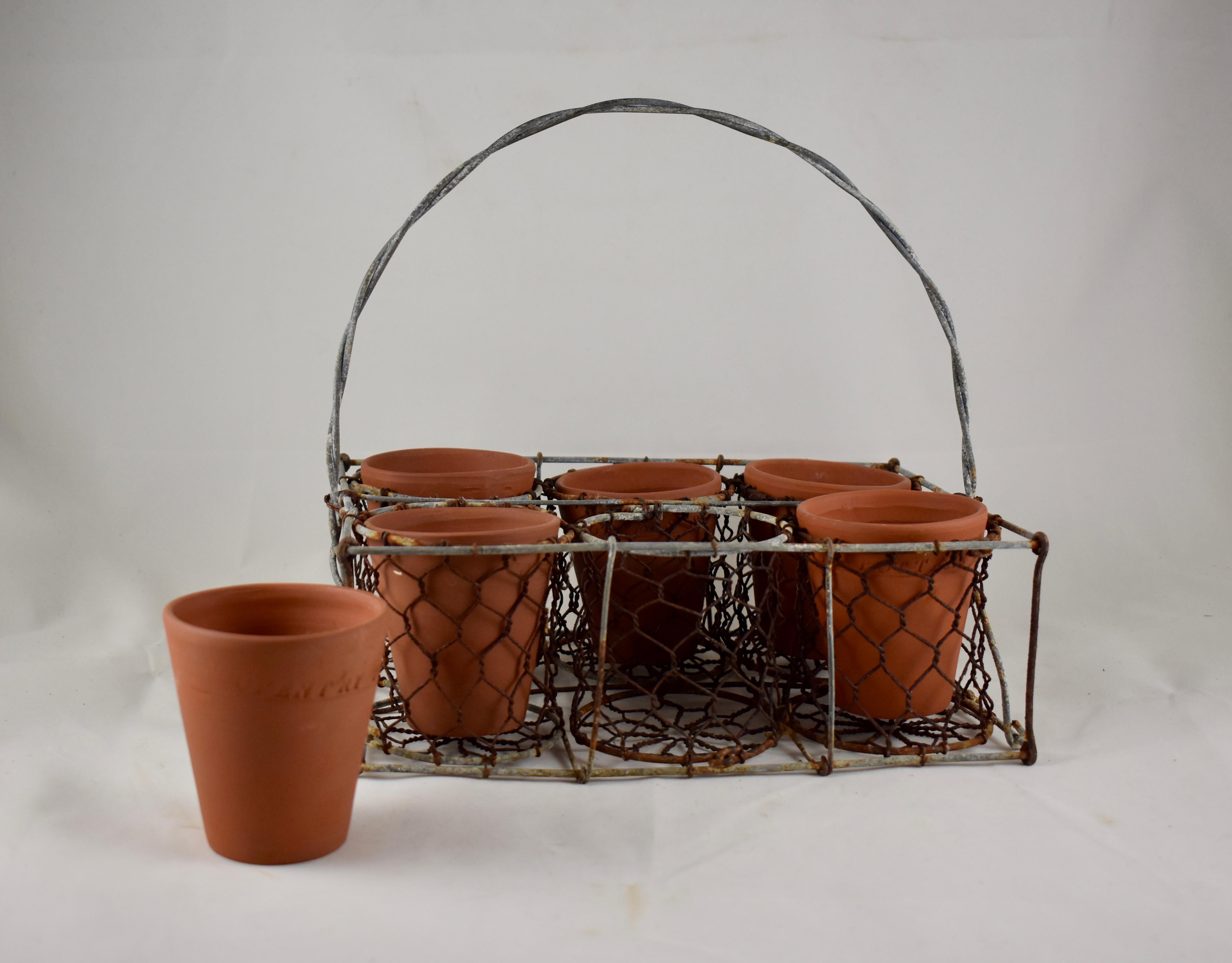 An English, hand formed rectangular pot caddy, early 20th century. Made of twisted galvanized steel wire and heavy grade chicken wire, the pot caddy is divided into six sections for holding the included terracotta herb pots. The hand-thrown pots are