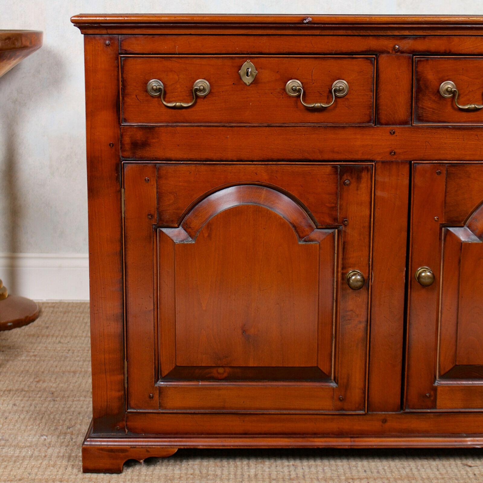 A fine quality early 20th century Arts & Crafts dresser base.
Of peg and tenon construction, the rectangular top with moulded edges above frieze drawers mounted with good handles and escutcheons, dovetailed jointing and clean interiors. A pair of