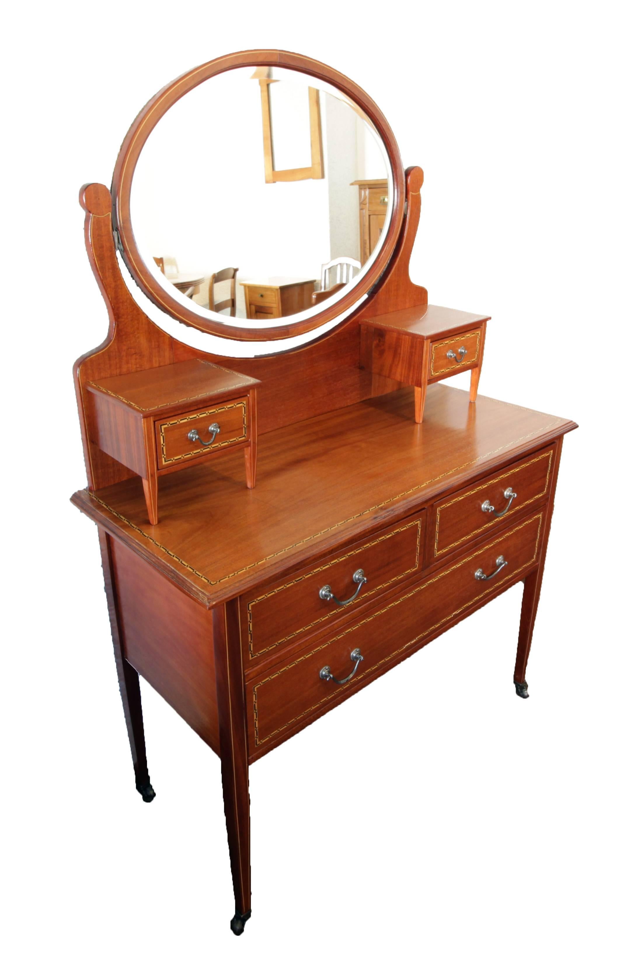 Well restored dressing table from circa 1900 from England. The table is made of mahogany with ribbon inlays.
