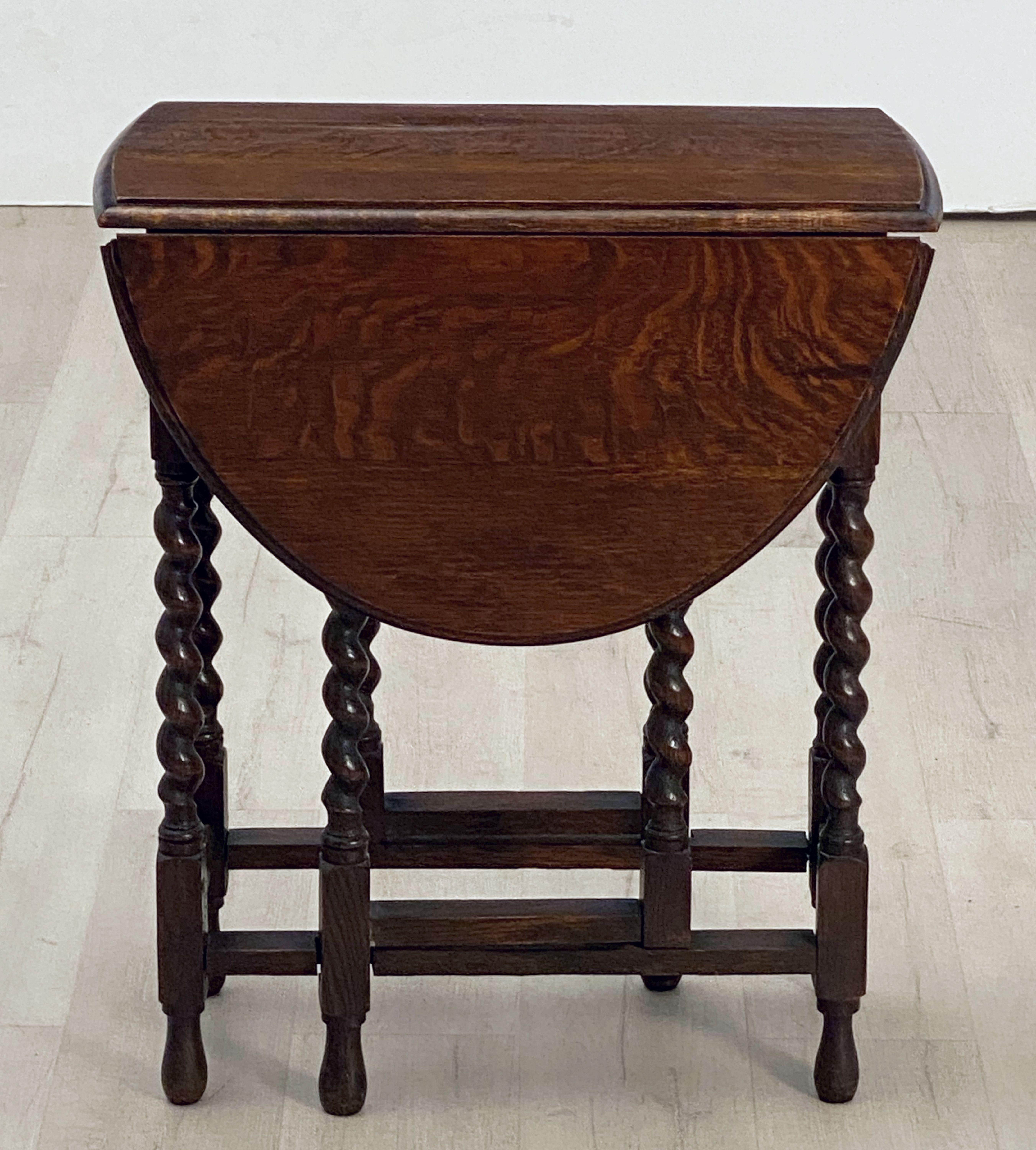 A Classic English drop-leaf gate-leg table of oak, featuring a moulded top with drop-down sides, over a stretcher of eight barley-twist supports.
Opens to an oval top.

Dimensions: 

Height 28 3/4 inches 
Width 24 1/2 inches 
Depth (closed)