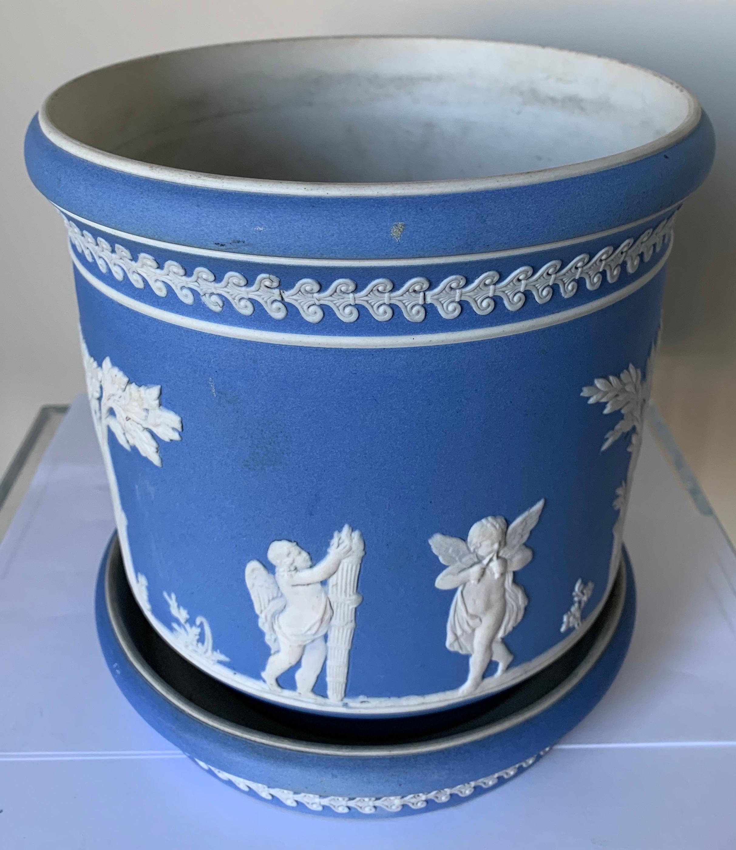 Dudson light blue and white jasperware pot on stand. Medium blue Jasperware with all over neoclassical motif.
Marked C on the underside. Pot has a center hole that has been filled in.
Underplate measures 1.5” tall x 7.5” wide. Pot measures 7.25”