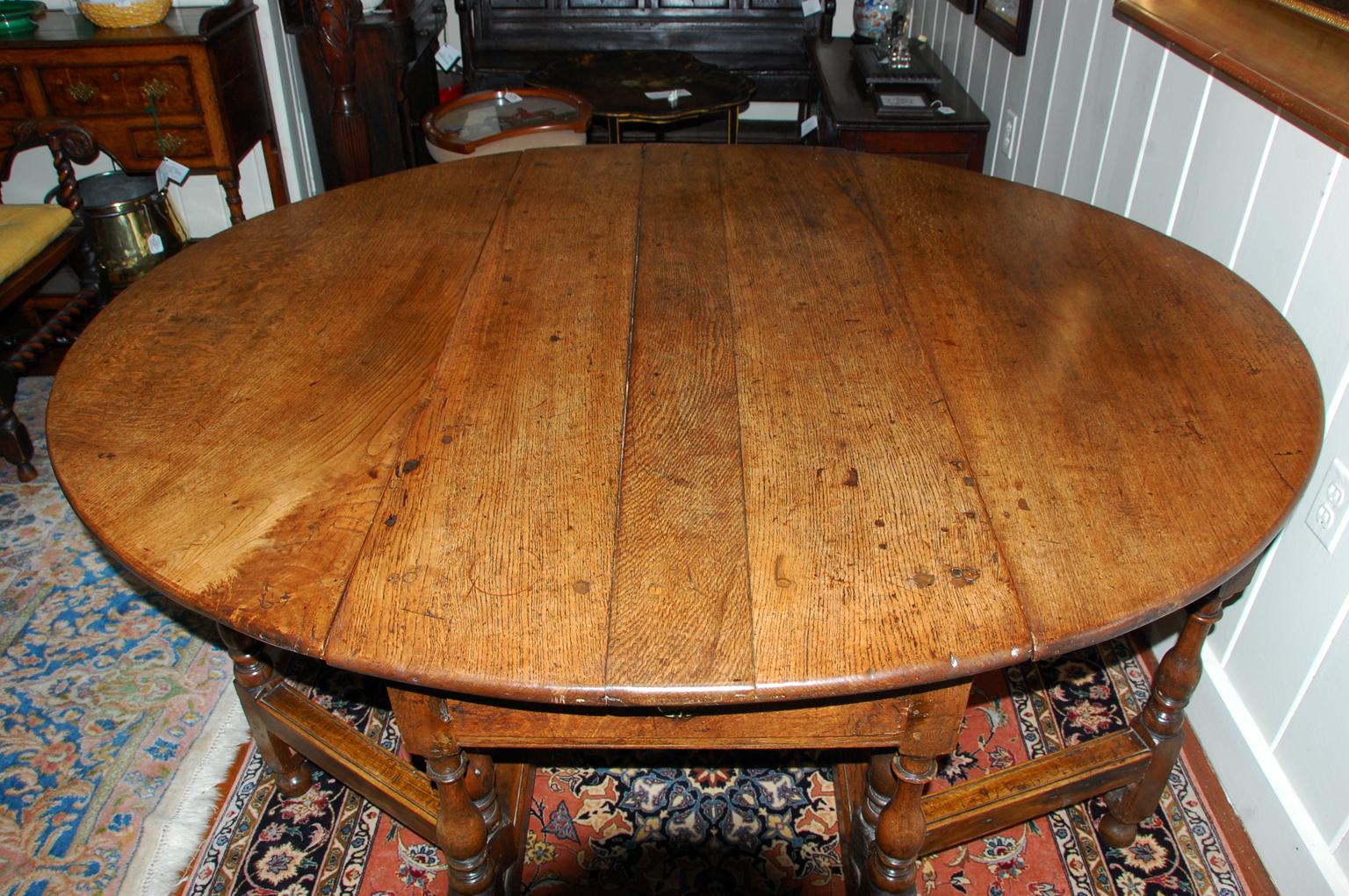 English early 18th century large oak dropleaf double swing leg dining table with two drawers, bold turnings, circa 1700-1740.