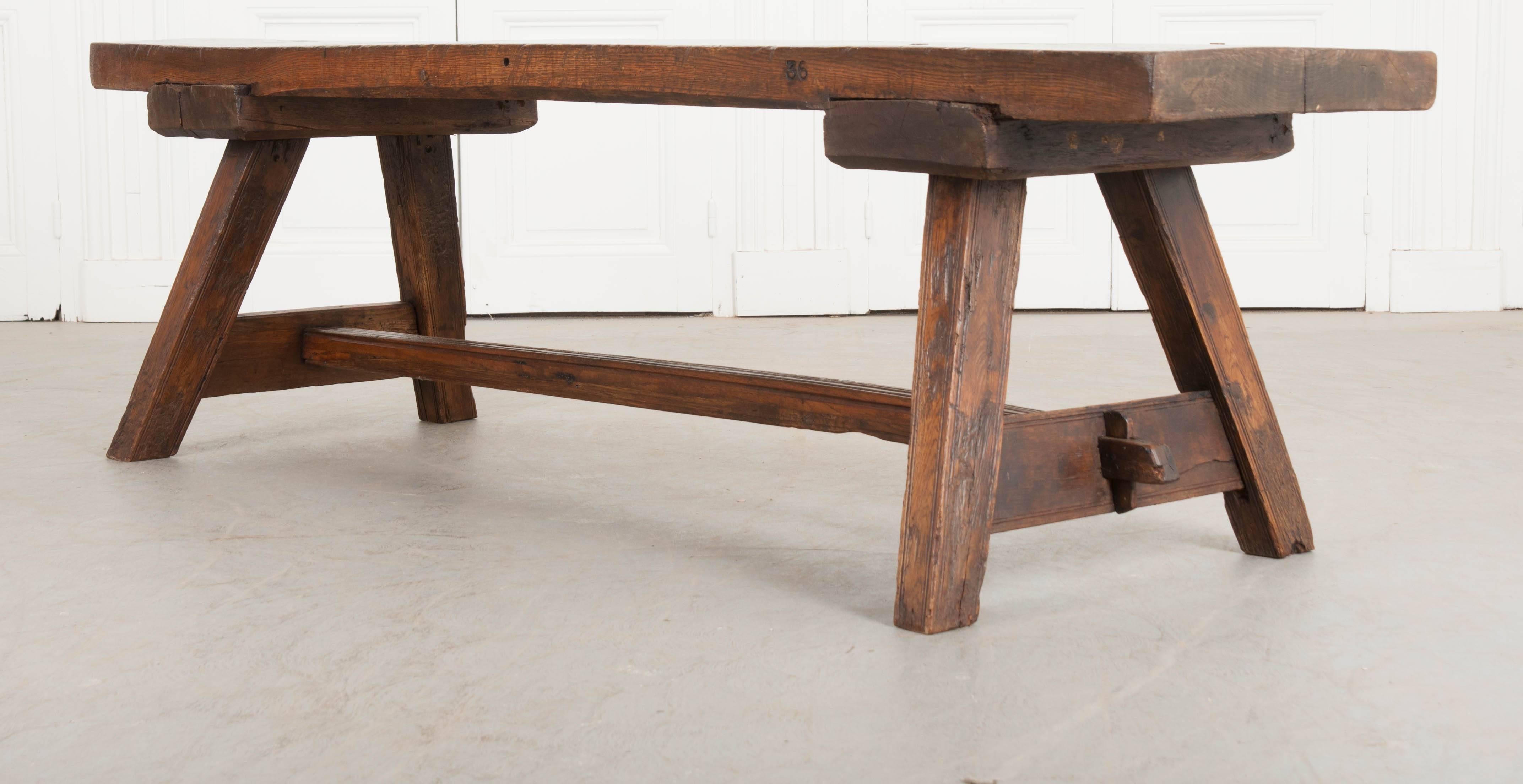 A single solid-oak board was used to make the top of this incredible 19th century English bench. The bench was made in the English countryside, circa 1830. The top is worn, with evidence of countless bottoms resting momentarily before going their