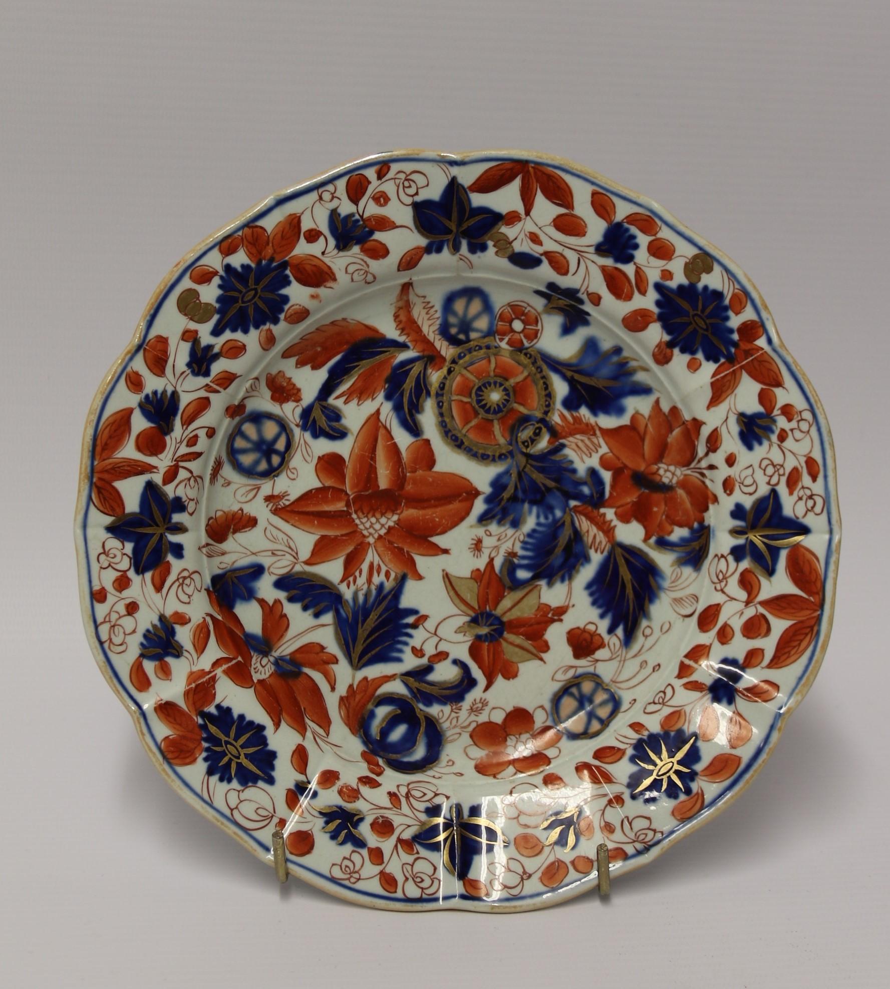 This vibrant early 19th century hand painted Masons Ironstone dessert service consists of a matching set of ten plates and a most unusual comport. This is raised on an oval base with twin supports. The plates and comport are beautifully hand painted