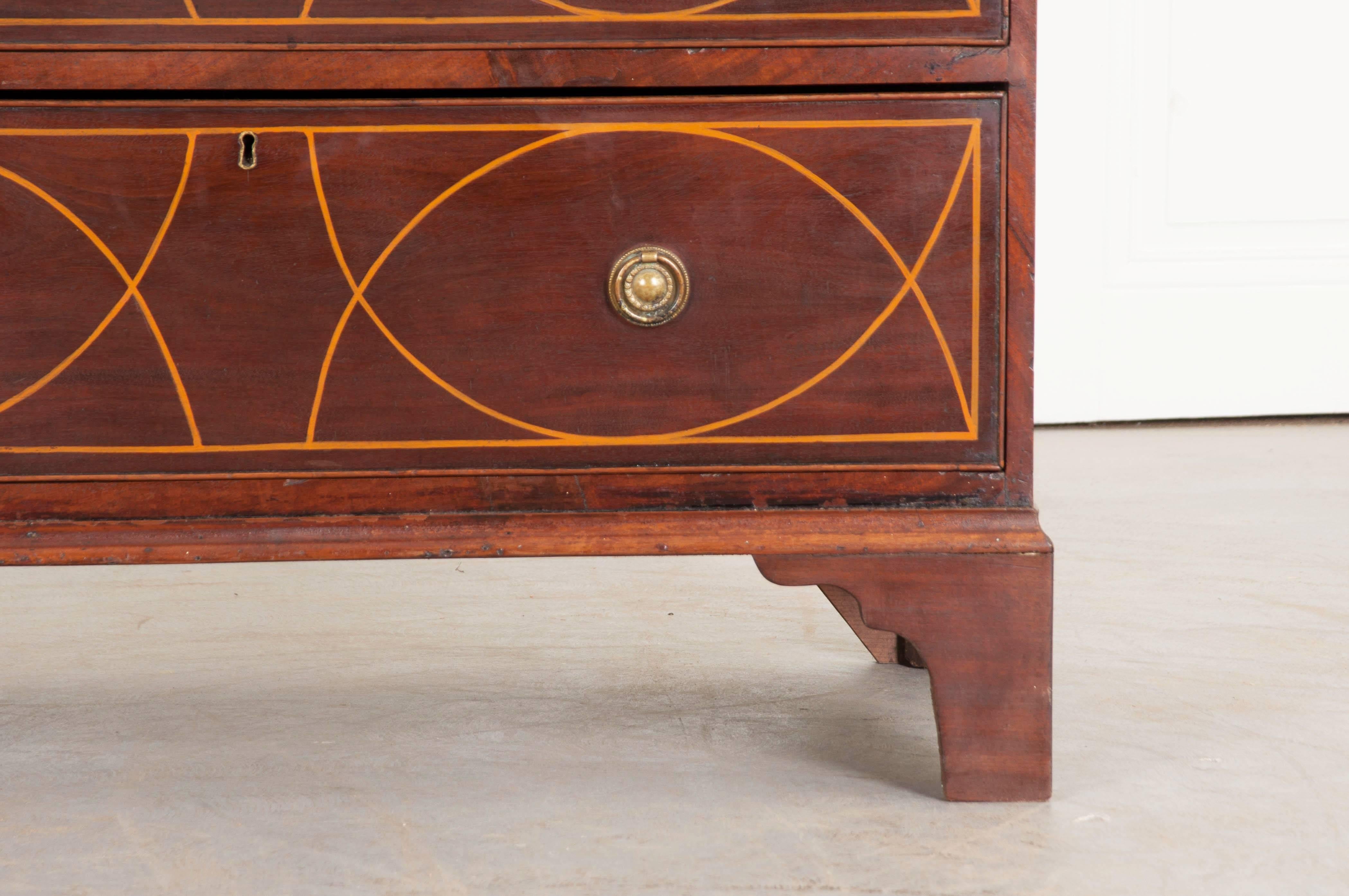 This magnificent five-drawer mahogany chest of drawers was made in England at the beginning of the 19th century. The classically styled antique chest features large semicircular-shaped arches that cross to form a fascinating design that seems to