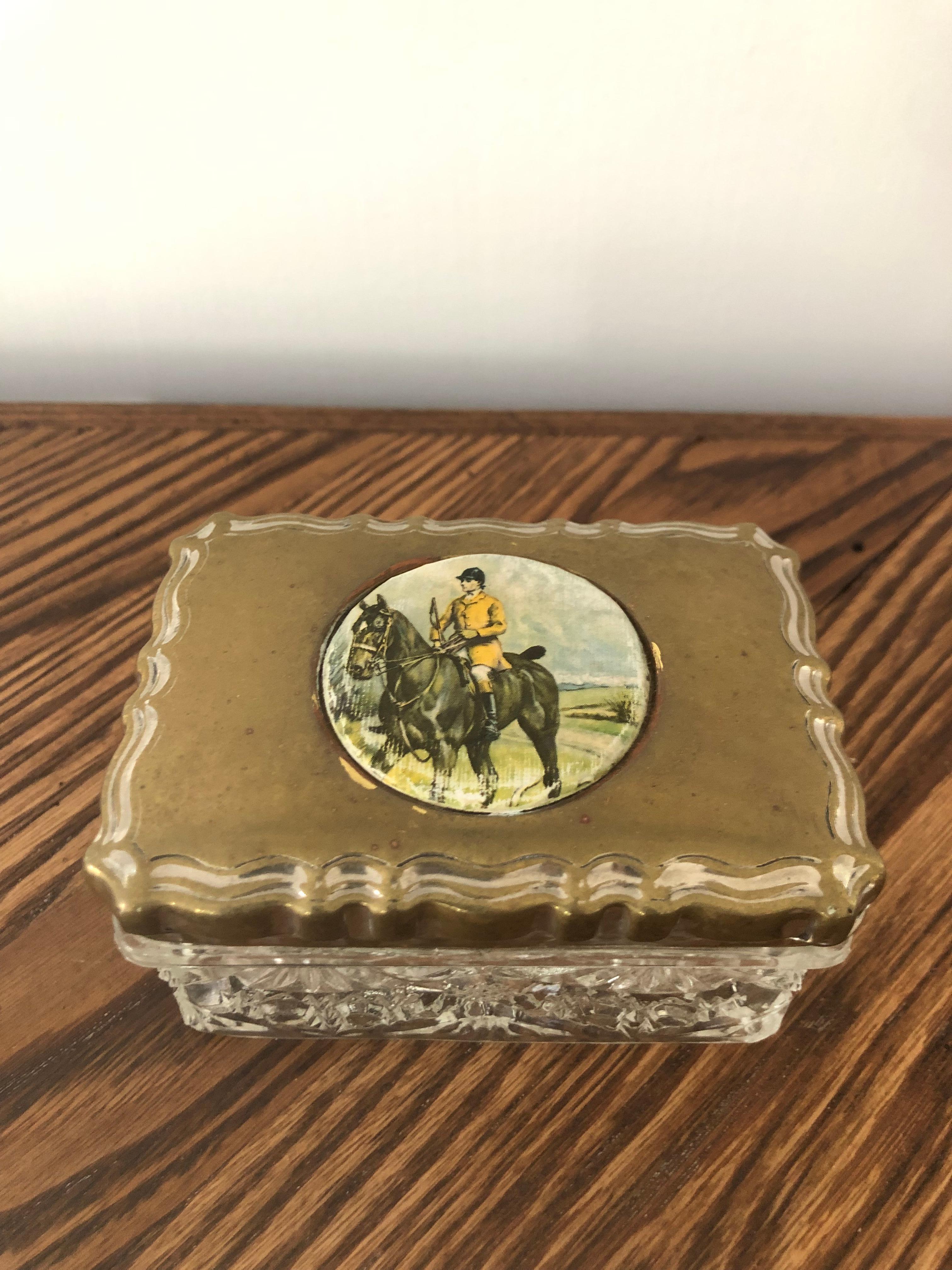 Early 20th century crystal dresser box with a hunting scene painted on a brass lid. This crystal box is a nice size and good quality that would look great on any dresser. Its from a private collector who traveled the world buying beautiful pieces.