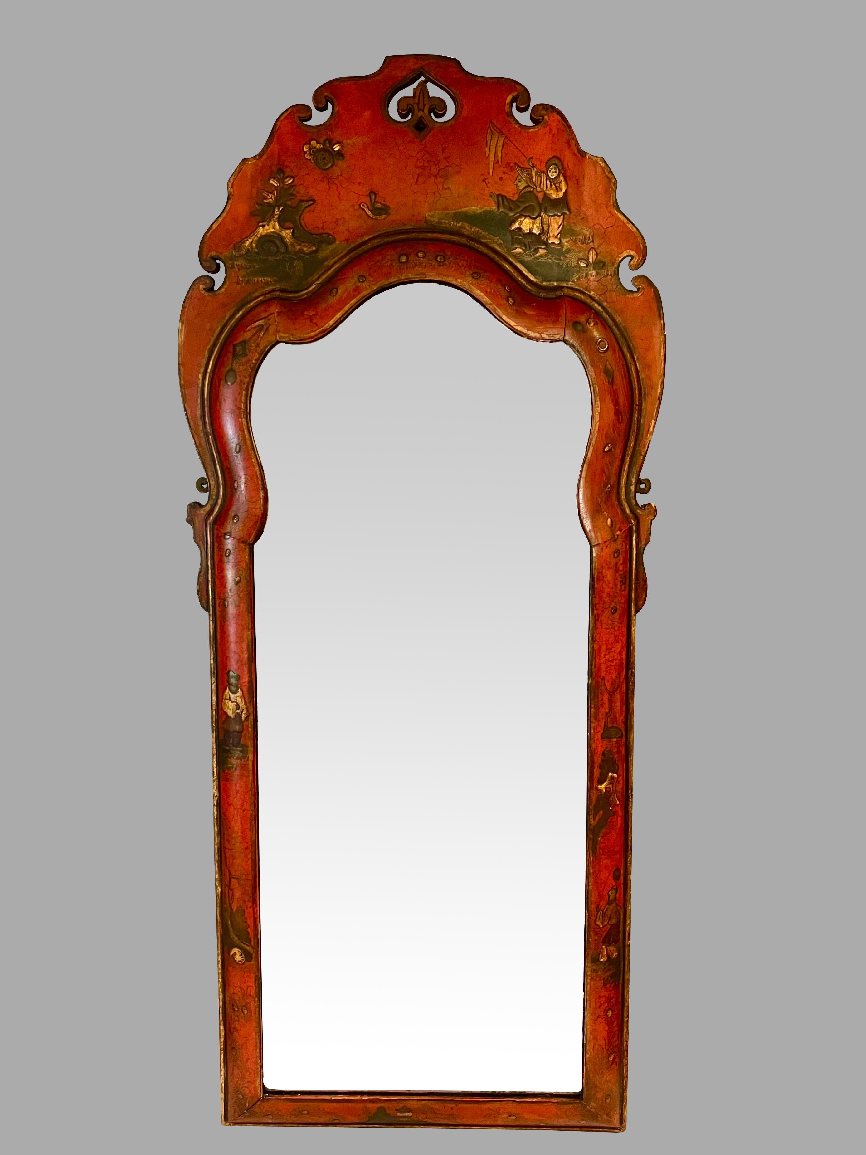 An English Georgian period red japanned pier mirror retaining an old possibly original beveled mirror plate. The piece is decorated in in an elegant restrained fashion the pierced cresting with figural decoration, the perimeter with foliate