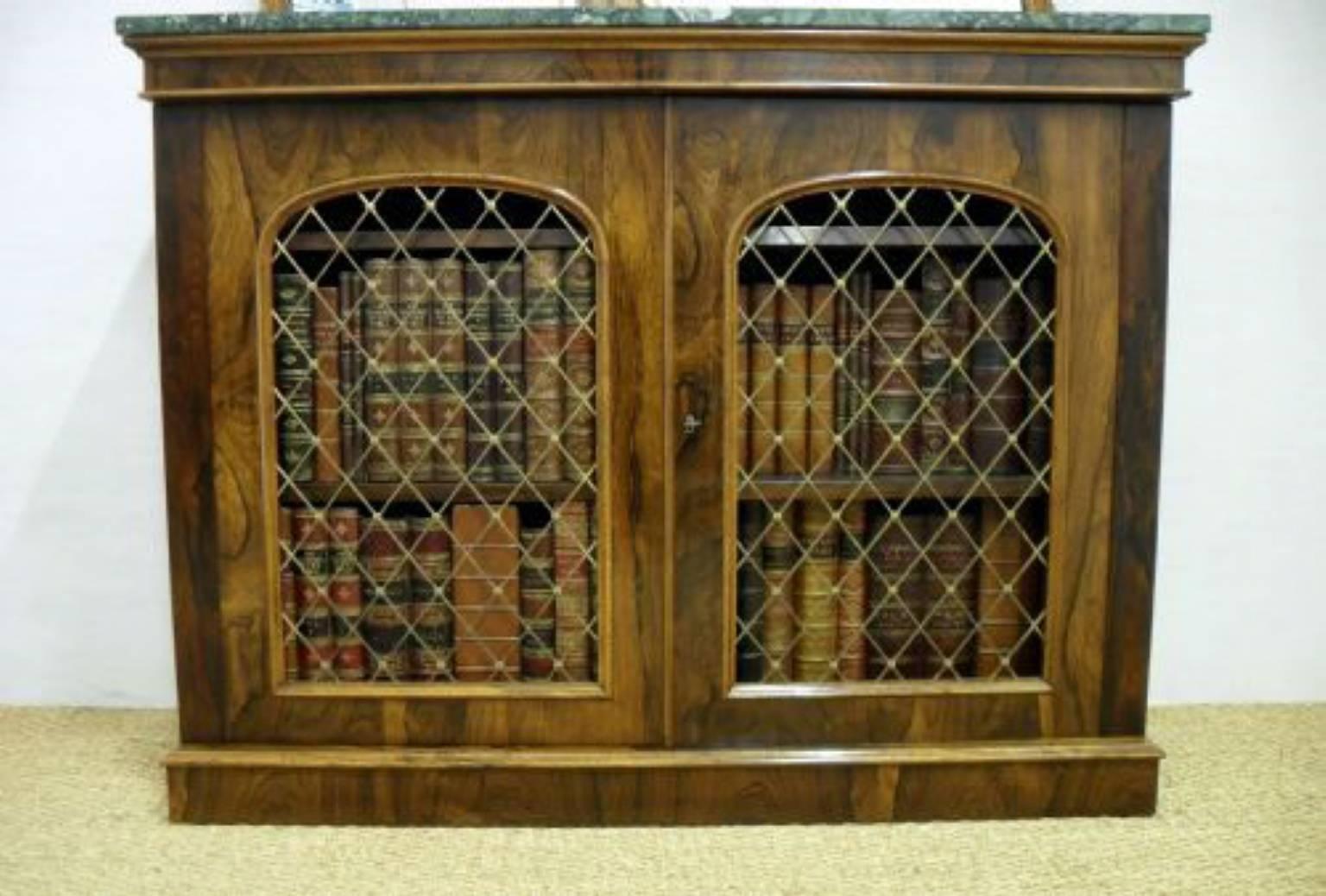 A superb quality early Victorian rosewood side cabinet with a carved mirror back, green marble top and brass grills to the doors. The cabinet could be used as a bookcase or as a small sideboard.

The cabinet is stamped with the makers name:-

W