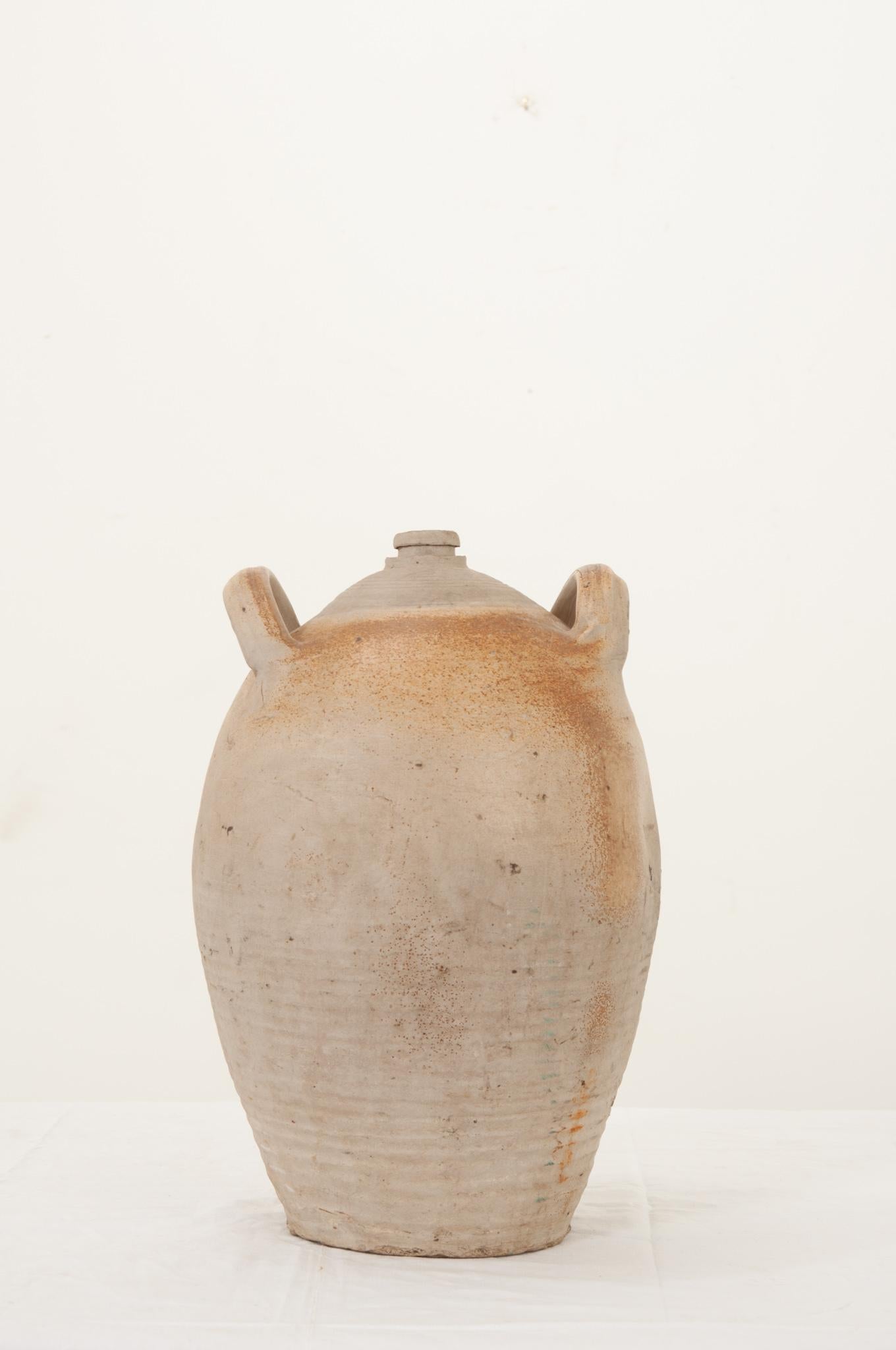 A fantastic earthenware culinary storage jar for olive oils from 19th Century England. In wonderful antique condition, the double handled vessel serves as a great neutral element in any space. The opening fits a standard size wine cork as you can