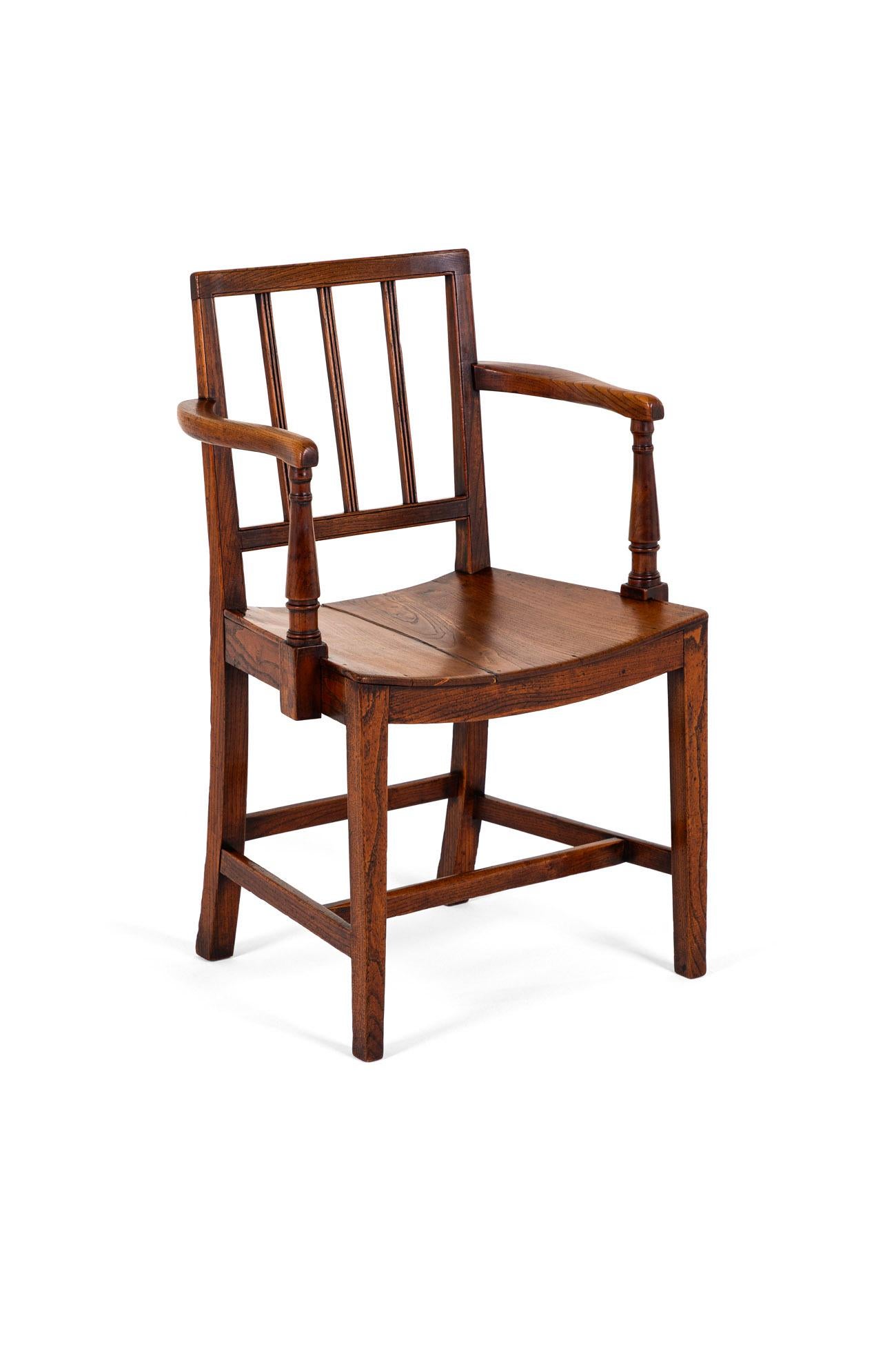 A lovely East Anglian Open Armchair in elm with wide open and turned uprights.

The chair has a welcoming square back with three back splats supports leading to a welcoming dished seat.

Finished on square block legs and united by peripheral
